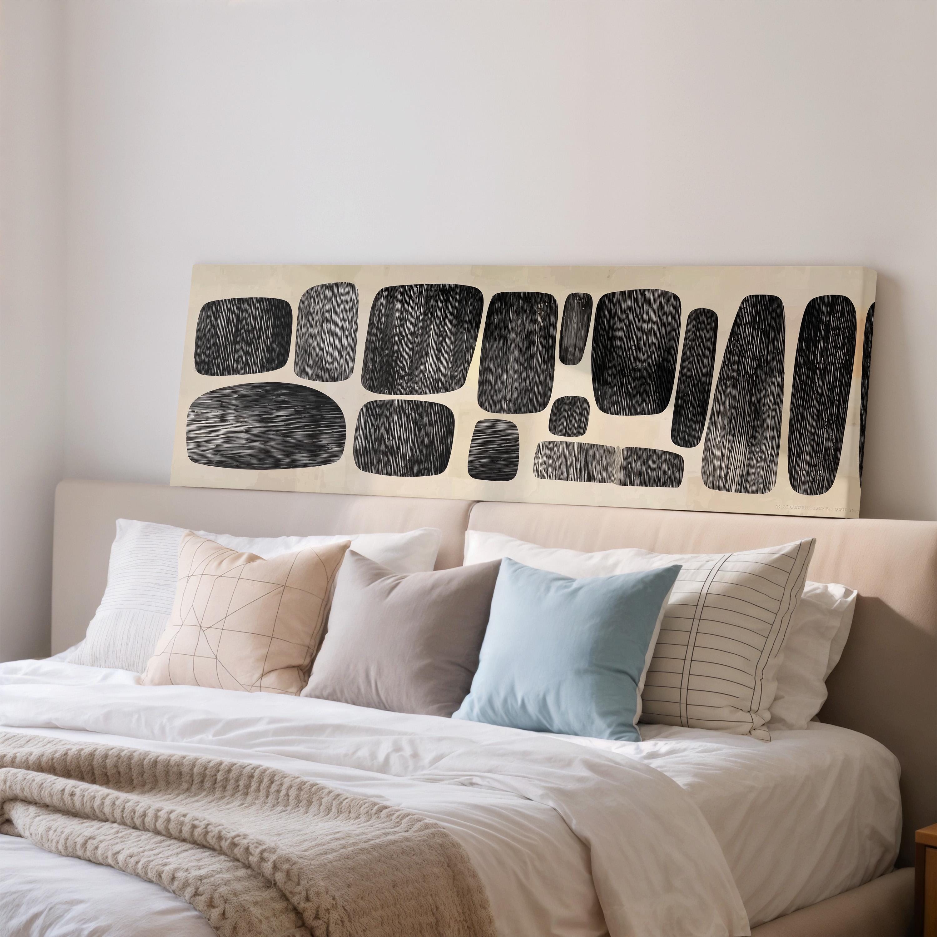 a well-made bed with a variety of pillows and a large abstract artwork displayed above it.