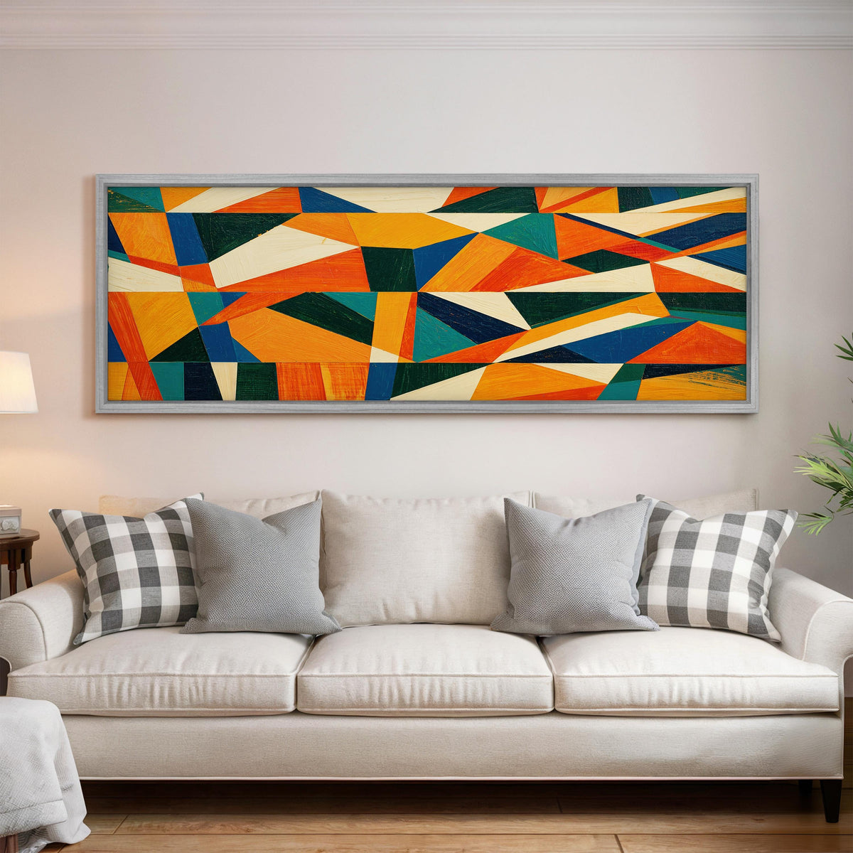 Orange and teal triangle mosaic panoramic canvas print above a white sofa in a bright living room