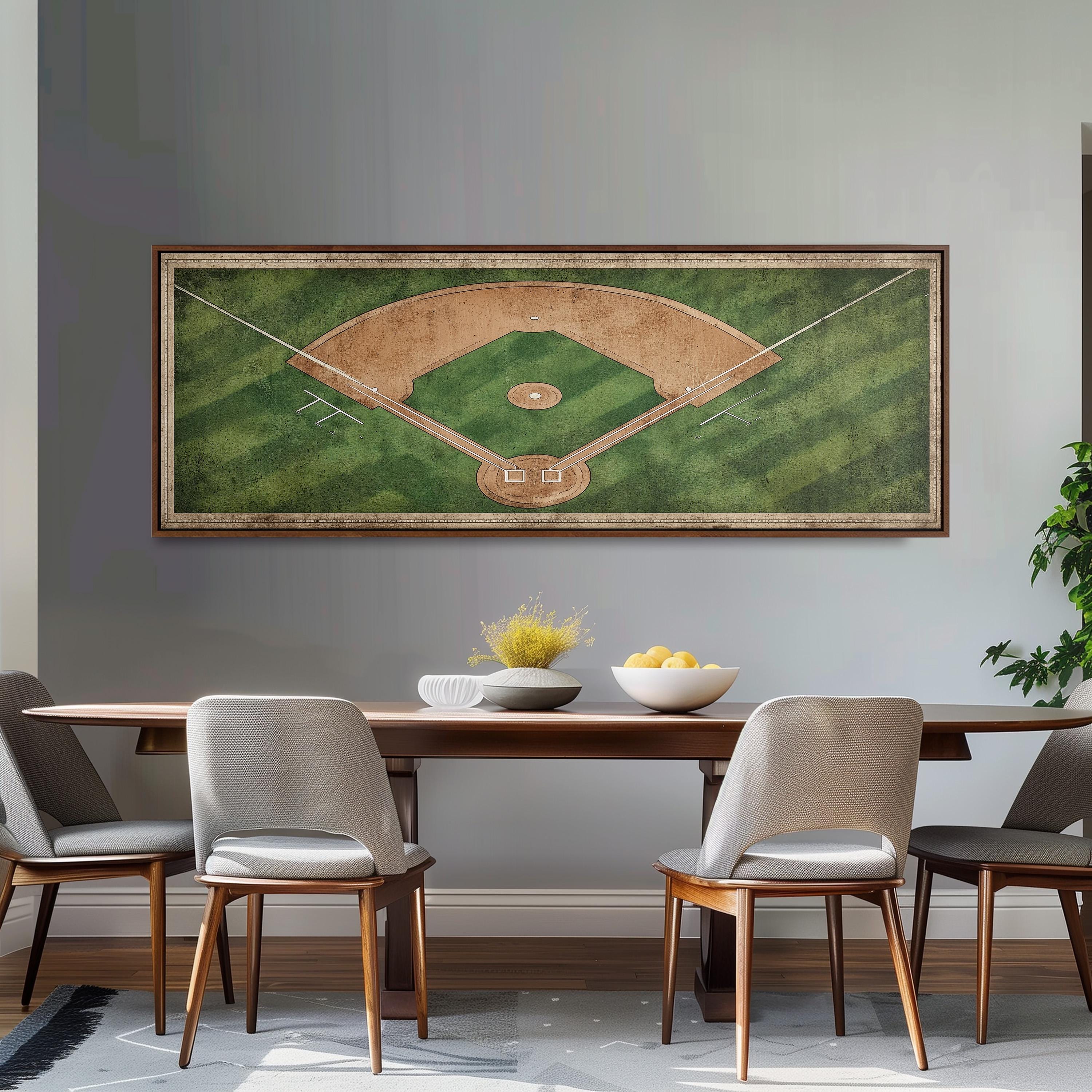 a dining room with a large framed picture of a baseball field hanging on the wall above a wooden dining table with four chairs. The table is set with a bowl of fruit and a vase of flowers, creating a welcoming atmosphere for a meal.