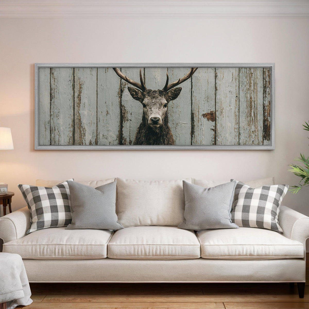 Monochrome stag on barn wood panoramic canvas print above a white sofa in a bright living room