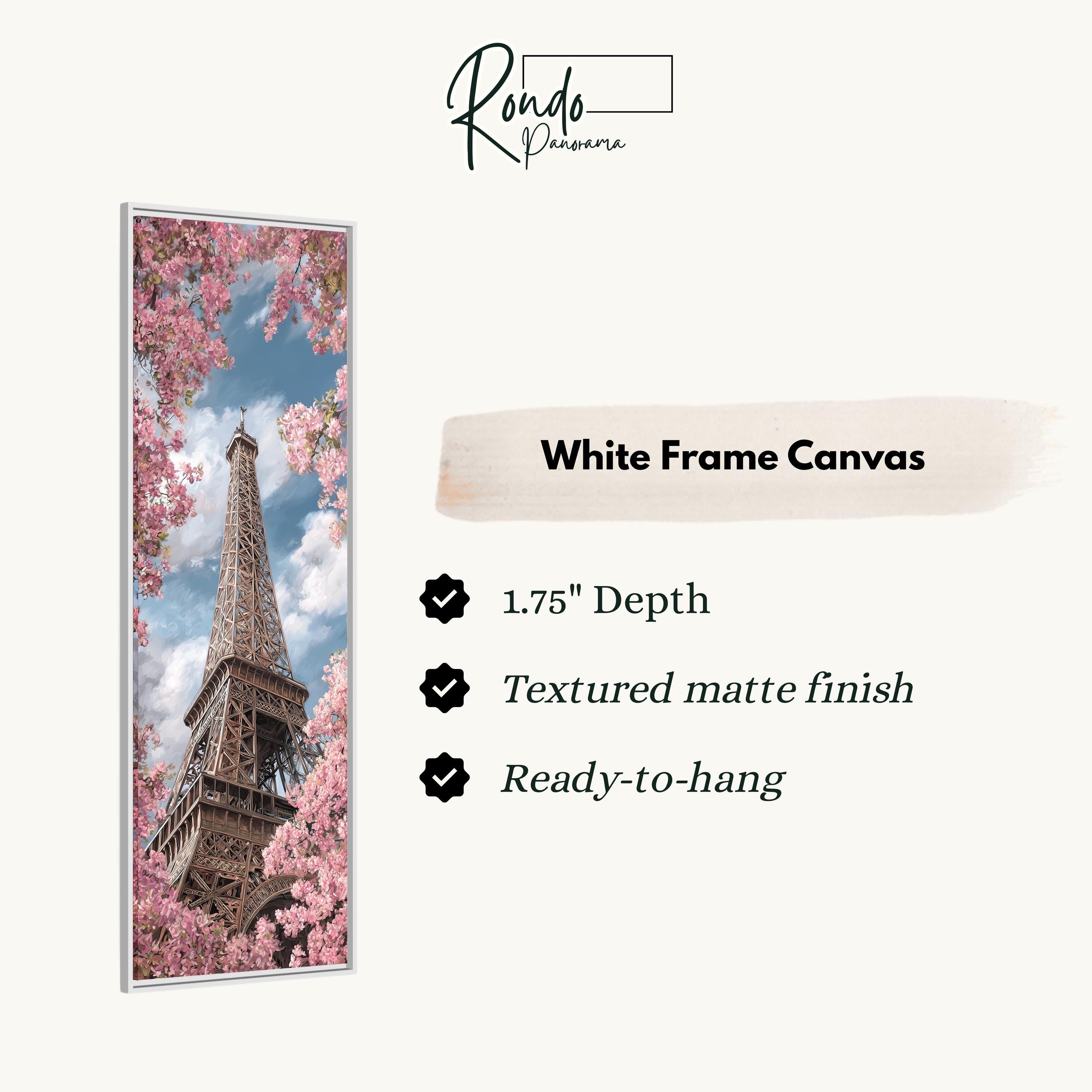 a white frame canvas with a close-up of the Eiffel Tower surrounded by pink flowers.