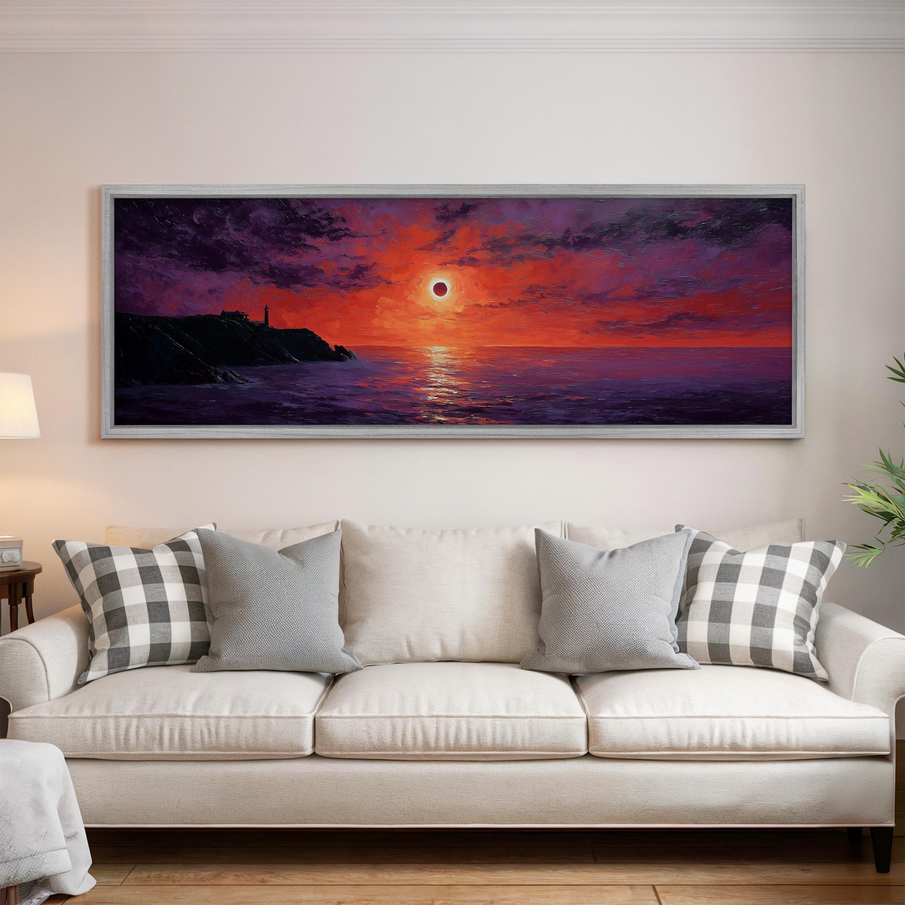 a large, framed painting of a sunset over the ocean hanging on a wall above a white couch with patterned throw pillows.