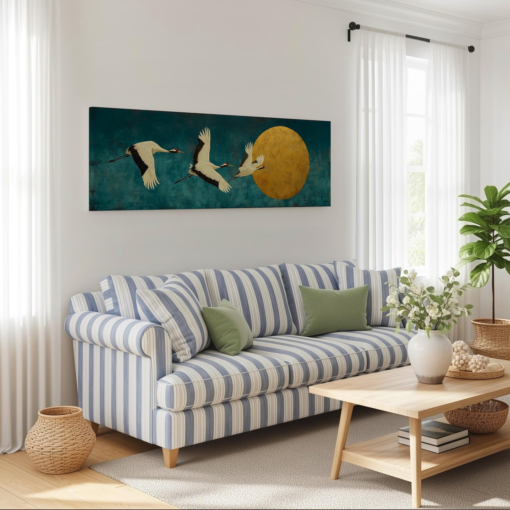a living room with a striped blue and white sofa, a wooden coffee table, and a large painting of three birds flying over a yellow moon on the wall.