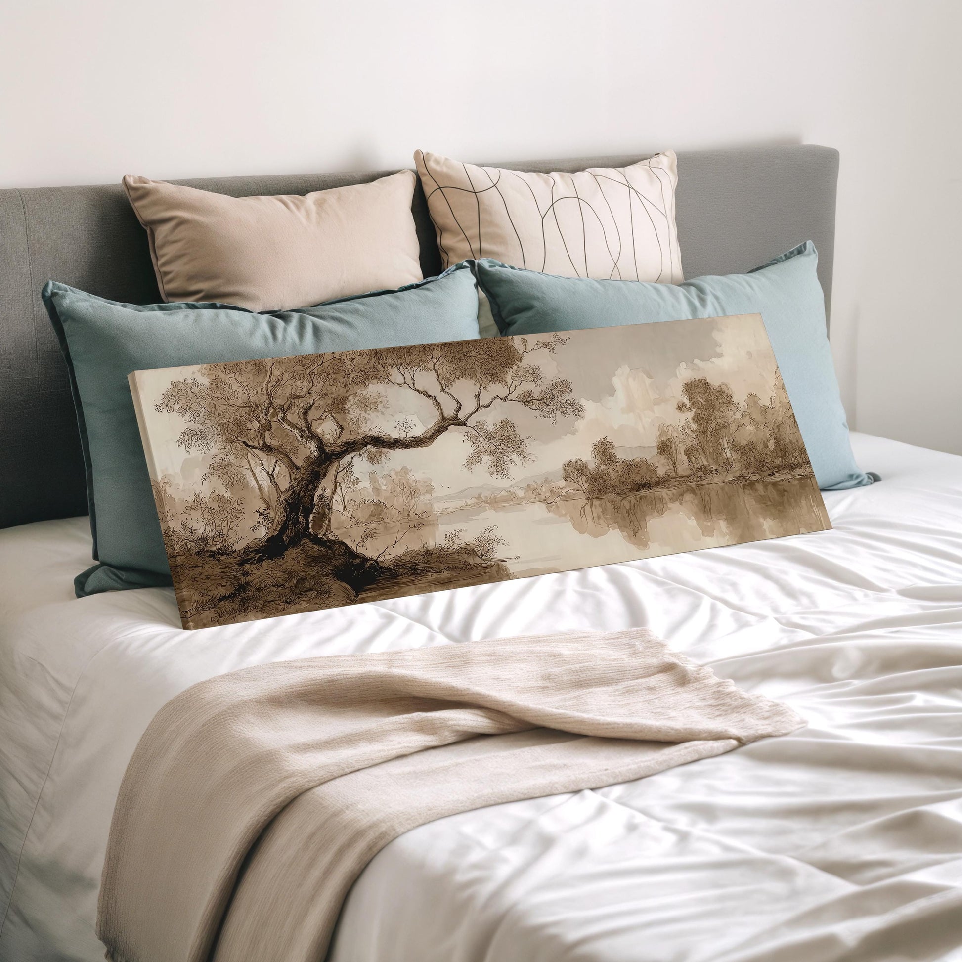 a bedroom with a bed and a painting of a landscape on it. The bed has a white comforter and is covered with multiple pillows. The painting is a landscape scene depicting a tree and a body of water.