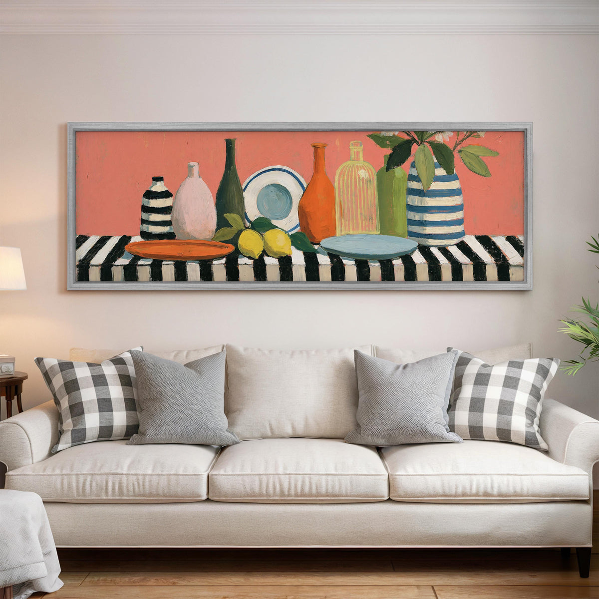 Bottles and lemons still life panoramic canvas print above a white sofa in a bright living room