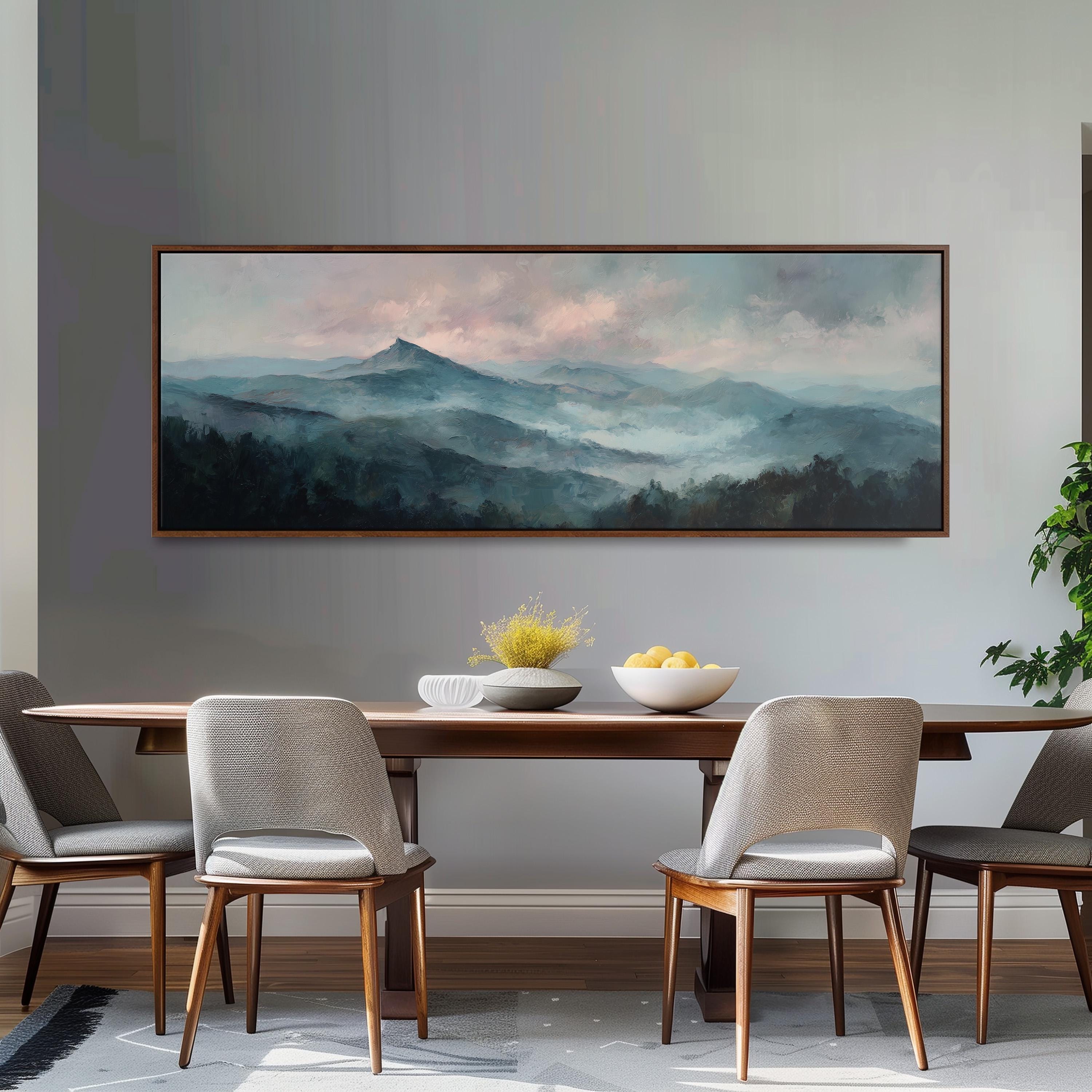 a dining room with a large painting of a mountain landscape hanging on the wall above a wooden dining table with four chairs. The table is set with a bowl of fruit and a vase of flowers, creating a cozy and inviting atmosphere.