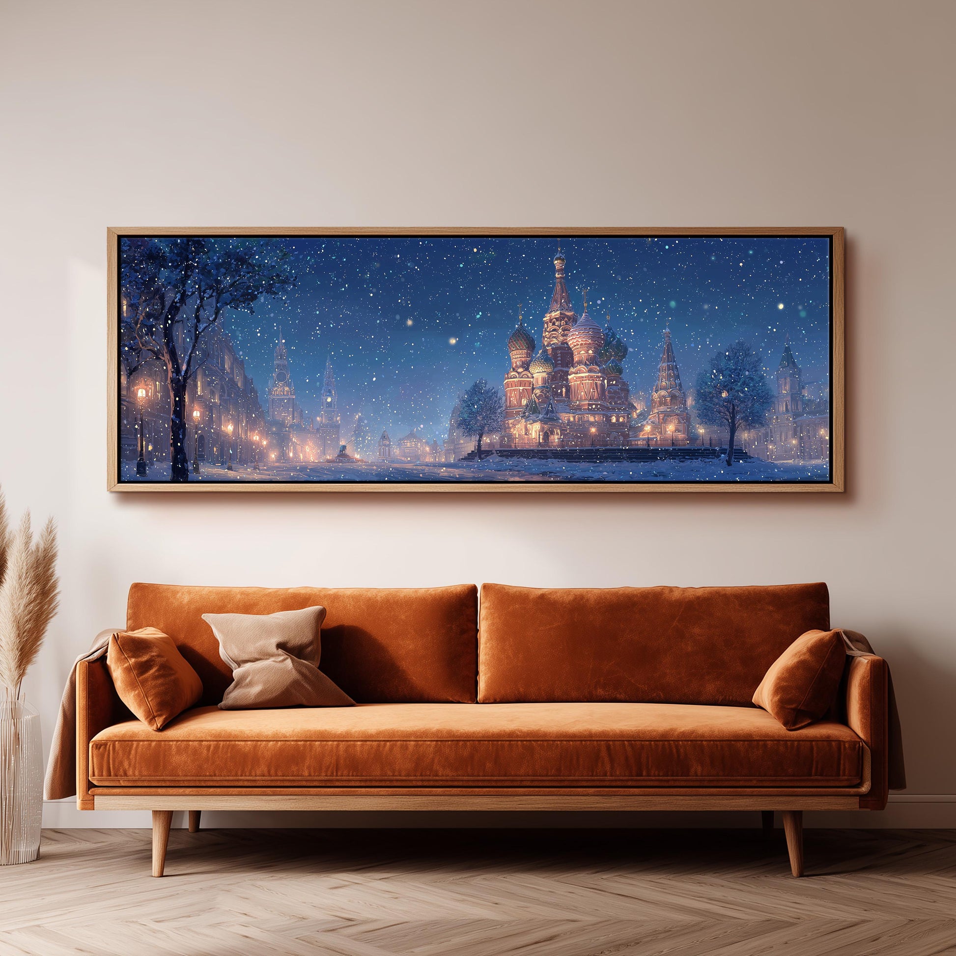 a large, framed painting of a snowy cityscape with a castle in the background, hanging on a wall above a brown sofa.
