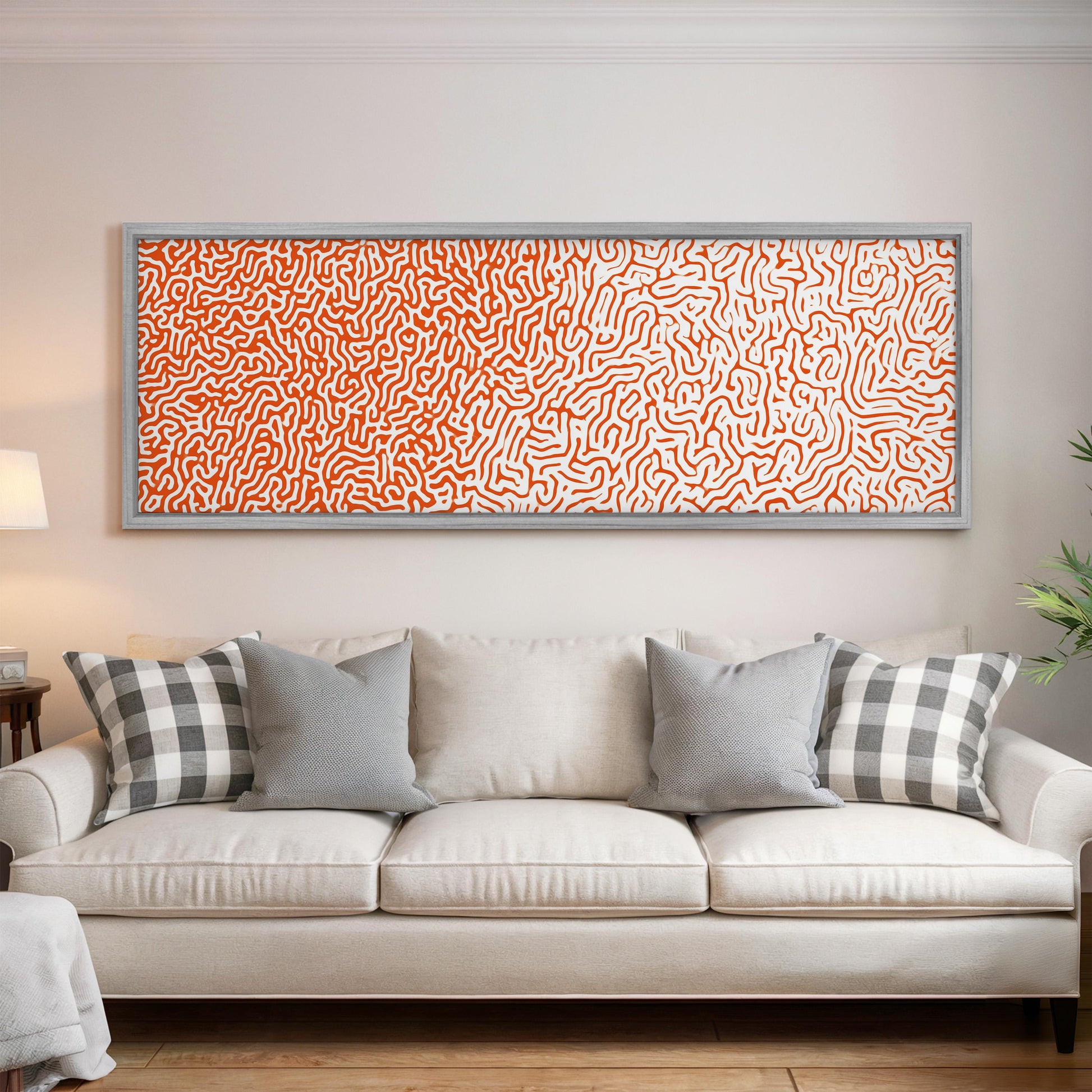 a large, rectangular, abstract painting hanging on a white wall above a white couch with gray and white patterned pillows.