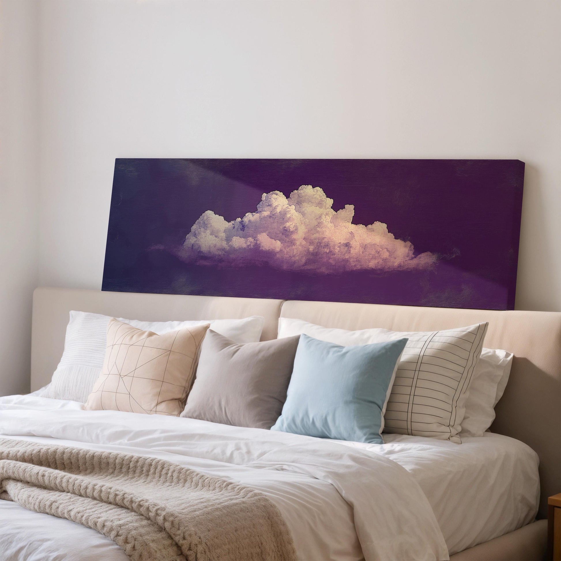 a large bed with white sheets and pillows, and a large canvas print of a cloud on the wall above it.