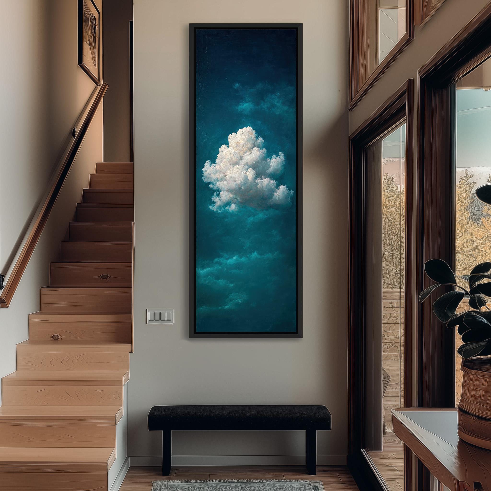 a large, framed painting of a cloud hanging on the wall of a hallway. The painting is positioned above a black bench, which is located in front of a window. The hallway has wooden stairs leading up to the painting, and there is a plant on the windowsill.