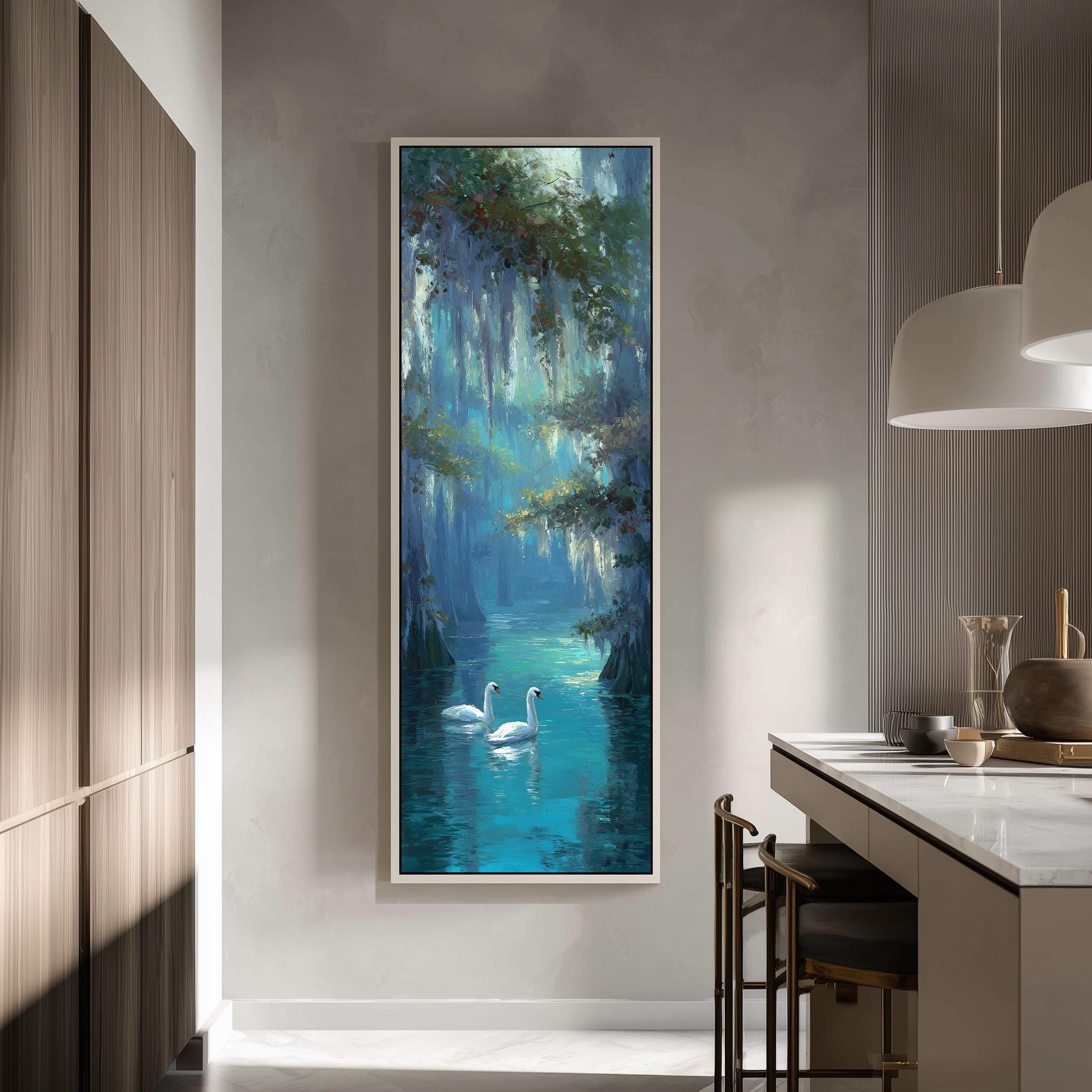 a large painting of two swans swimming in a tranquil blue lake, surrounded by lush greenery. The painting is hung on a wall in a modern, minimalist room with a kitchen counter and chairs visible in the background.