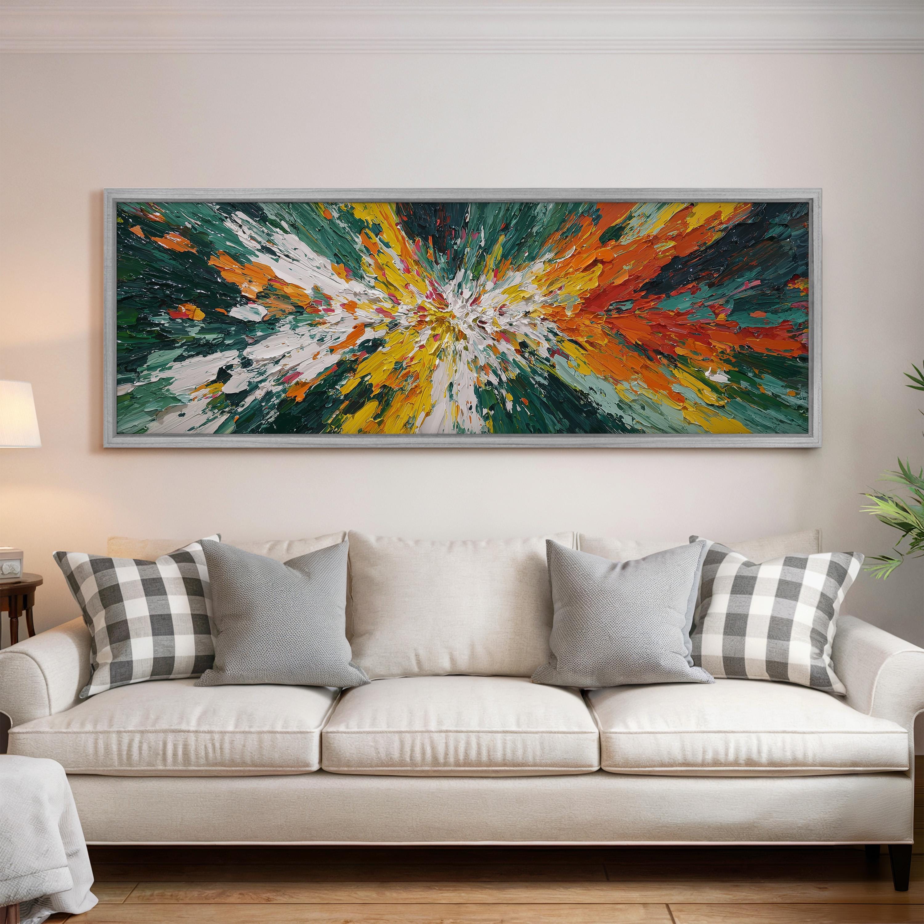 a large, colorful abstract painting hanging on a wall above a white couch with gray and white plaid throw pillows.