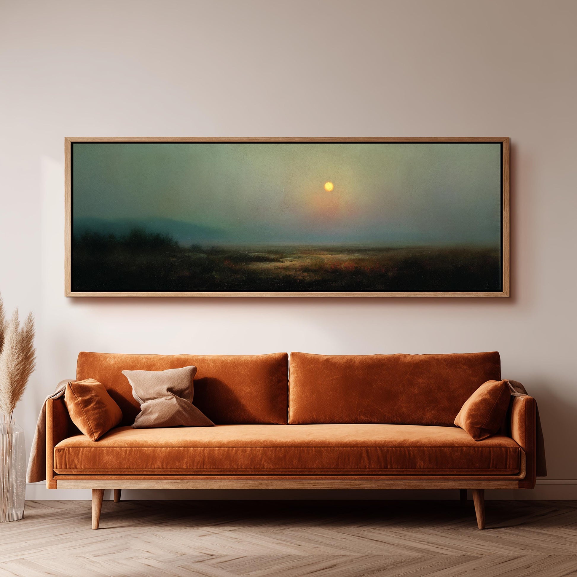 a large, rectangular painting hanging on a wall above a brown sofa with two pillows.