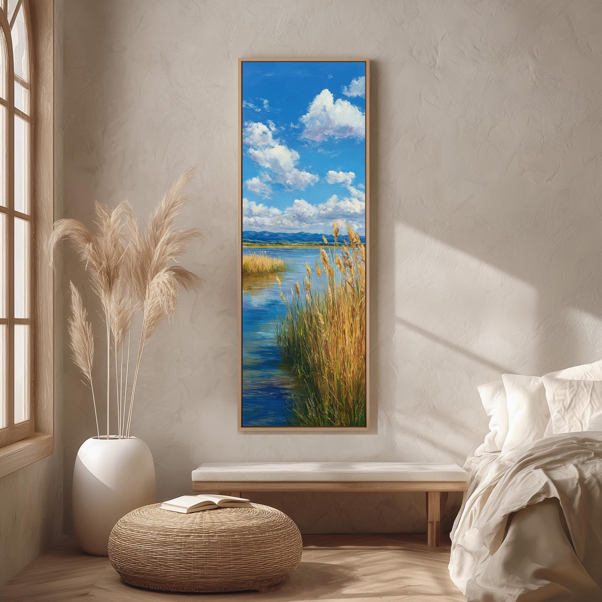a serene bedroom scene with a large painting of a tranquil landscape hanging on the wall, depicting a river and a blue sky with fluffy white clouds. The room is decorated with a white bed, a wicker ottoman, and a potted plant, creating a peaceful and inviting atmosphere.