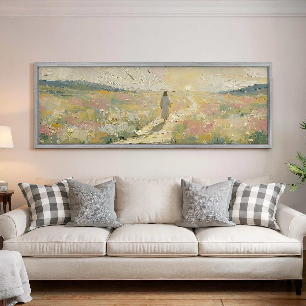 Jesus walking a pastel meadow path panoramic canvas print above a white sofa in a bright living room