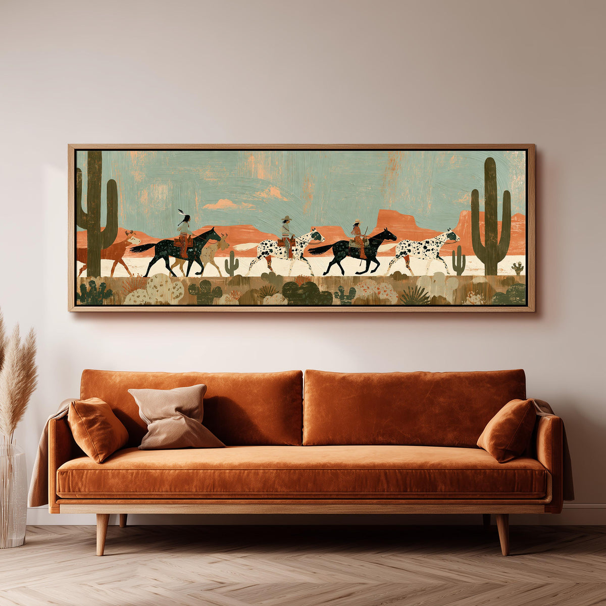 Riders on spotted horses across a red rock desert panoramic canvas print above a sofa in a living room