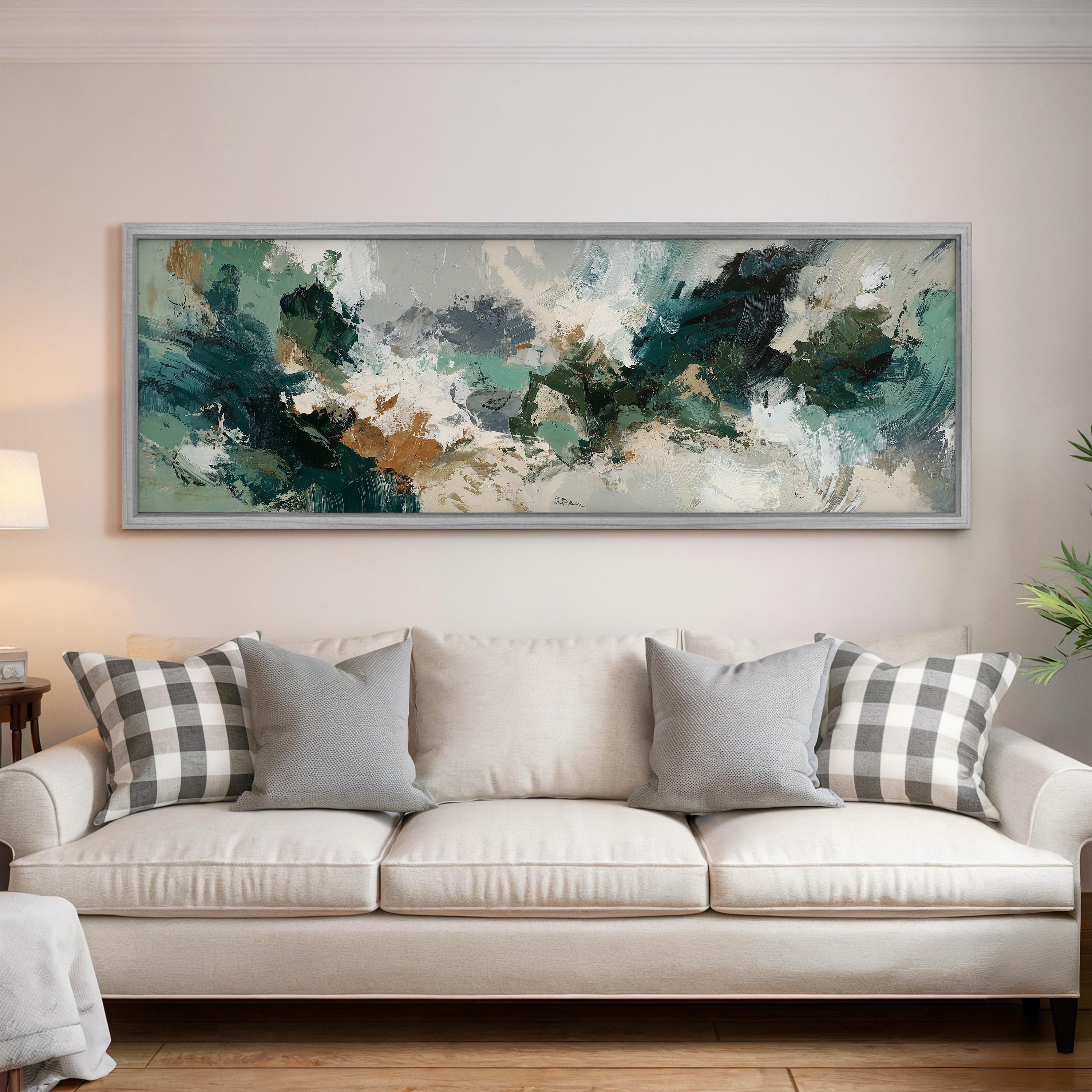 a large, abstract painting hanging on a wall above a white sofa with gray and white plaid throw pillows.