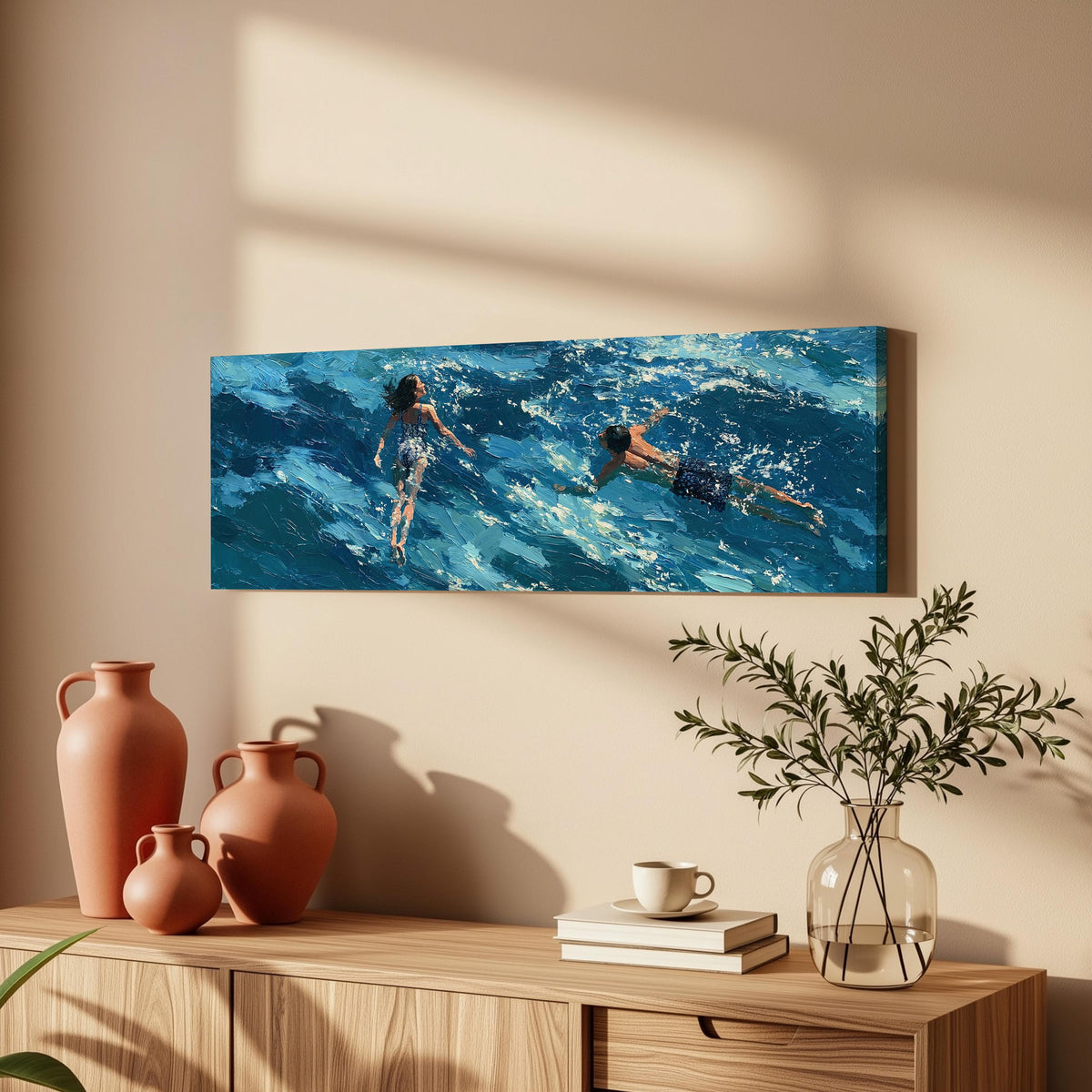 Two swimmers in turquoise waves long horizontal canvas print above a wooden sideboard