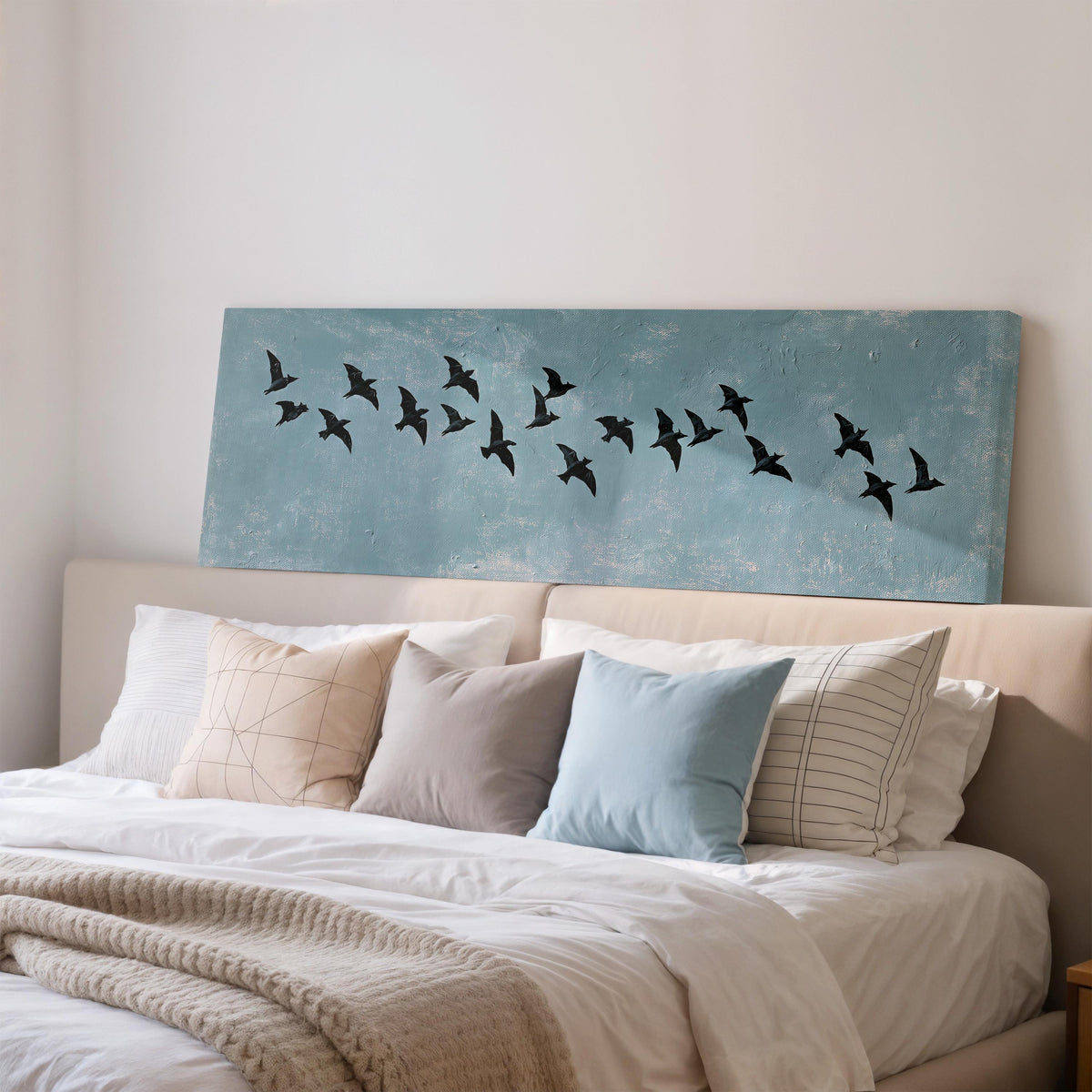 Flock of black birds on a teal sky wide panoramic canvas print above a bed in a bedroom