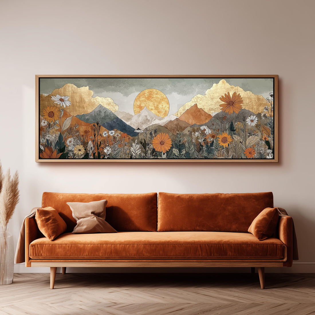 a large, framed painting of a mountainous landscape with a sun in the sky, hanging on a wall above a brown sofa.