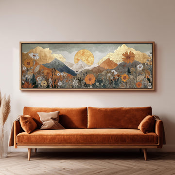 a large, framed painting of a mountainous landscape with a sun in the sky, hanging on a wall above a brown sofa.