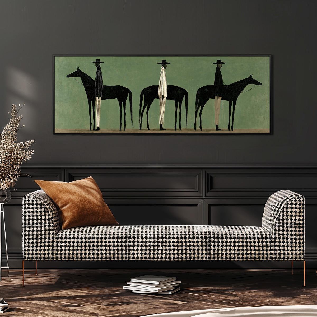 Three stylized cowboys with horses on sage green wide panoramic canvas print above a bench in a dark living room