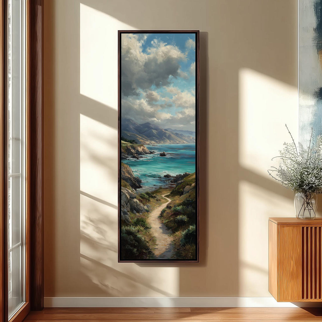 a large painting of a coastal landscape hanging on the wall of a hallway. The painting depicts a winding path leading to a serene body of water, surrounded by mountains and lush greenery. The hallway is well-lit, with a wooden staircase and a bench in the foreground. The painting adds a sense of tranquility and natural beauty to the space.