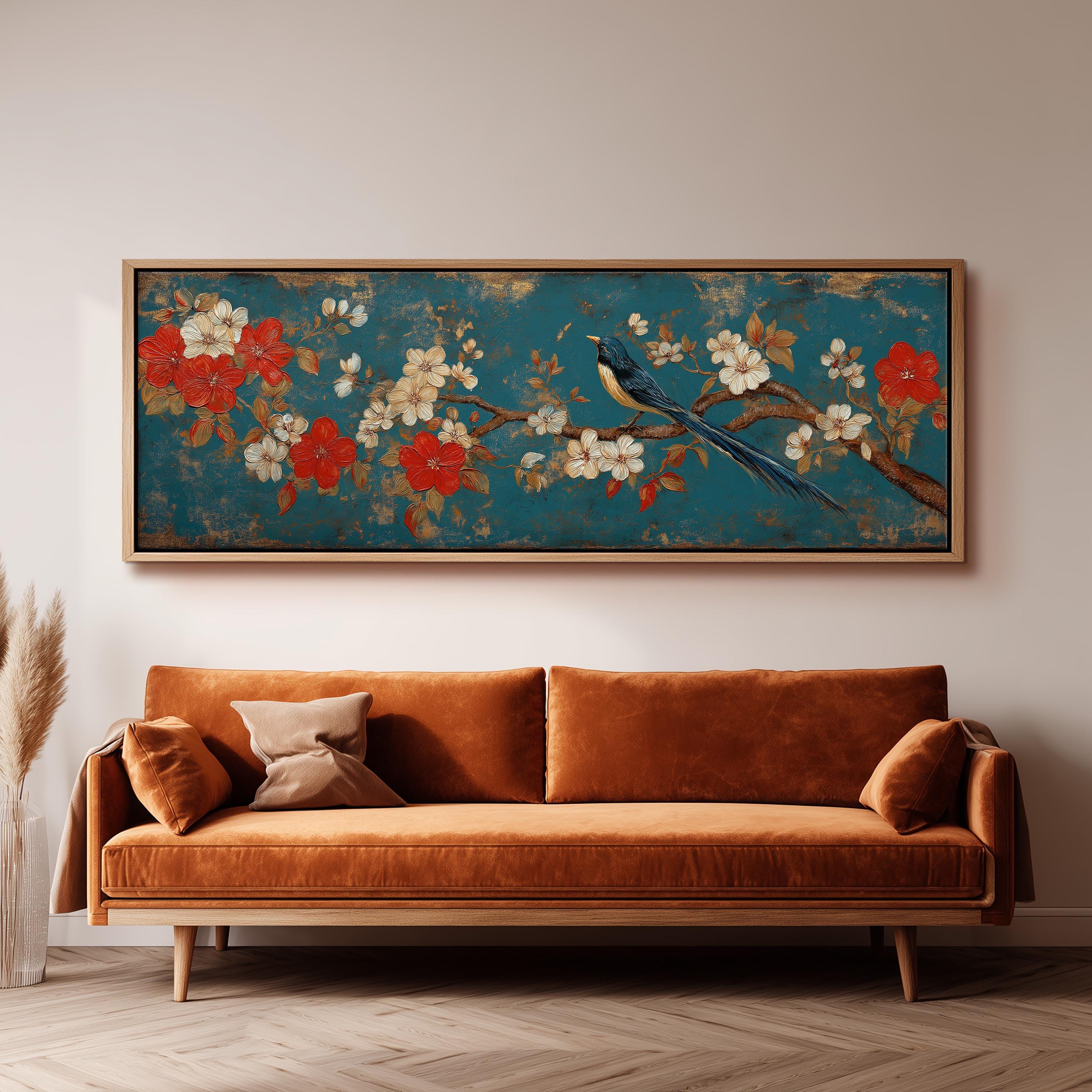 a large, framed painting of a bird perched on a branch with flowers, hanging on a wall above a brown sofa.