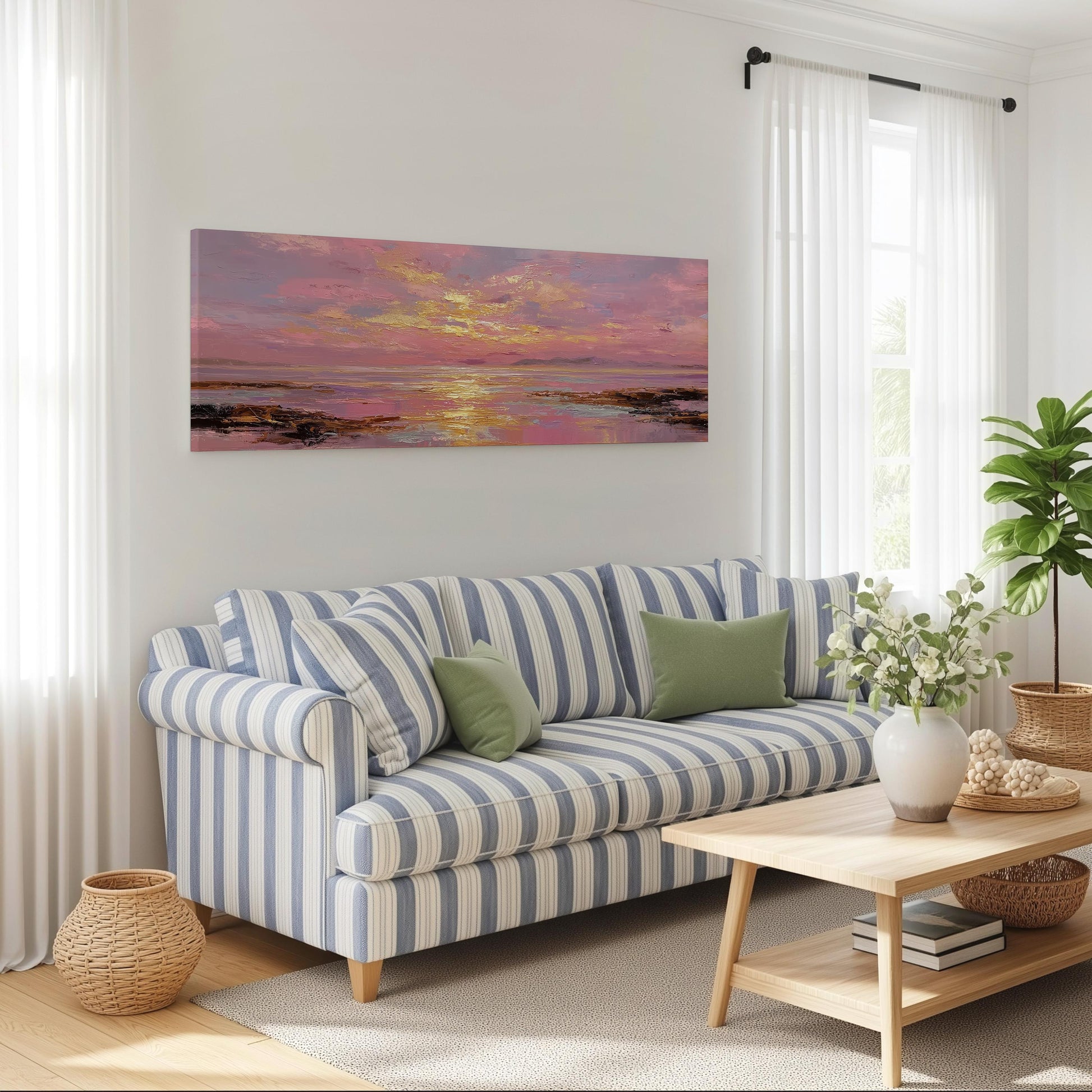 a cozy living room with a striped blue and white sofa, a wooden coffee table, and a large window with white curtains. Above the sofa, there is a large painting of a sunset over the ocean.