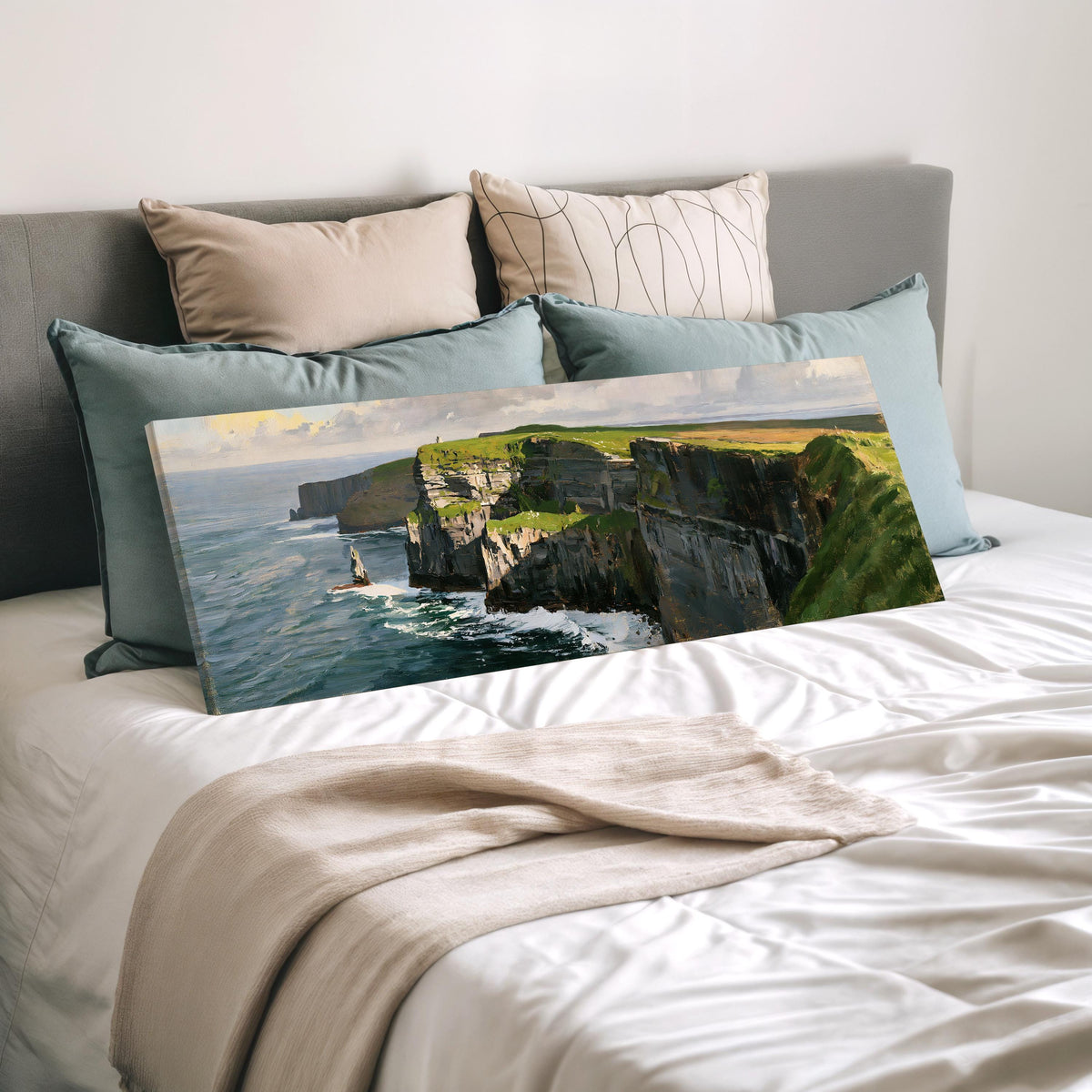 Sunlit sea cliffs with a sea stack wide panoramic canvas print laid on a bed to show its size