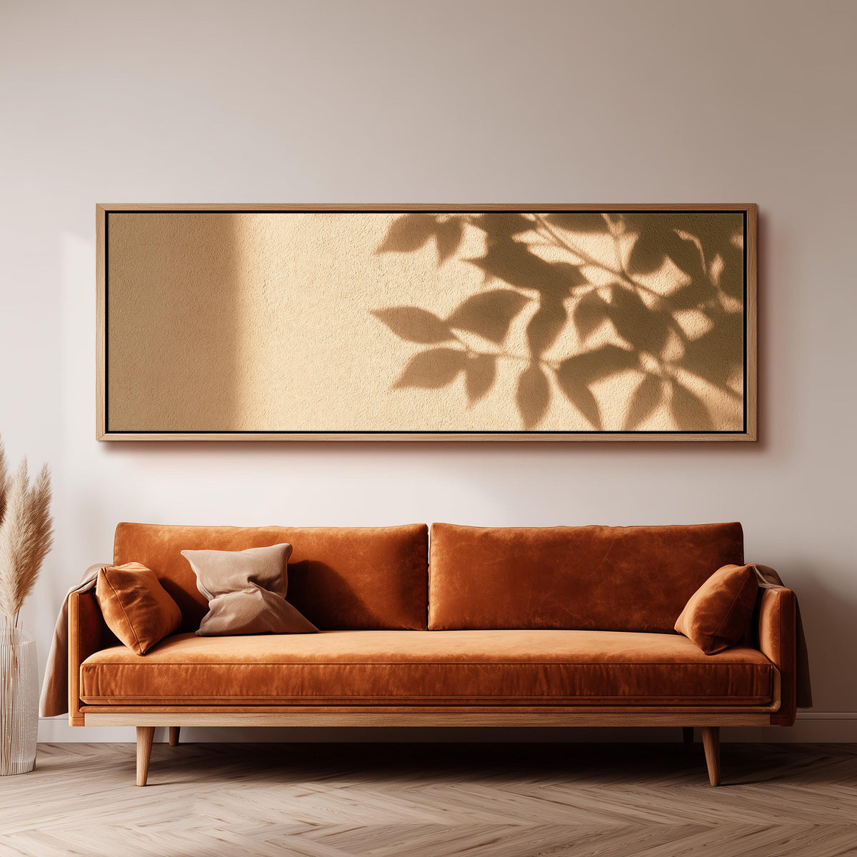 Leaf shadows on a golden plaster wall panoramic canvas print above a sofa in a living room