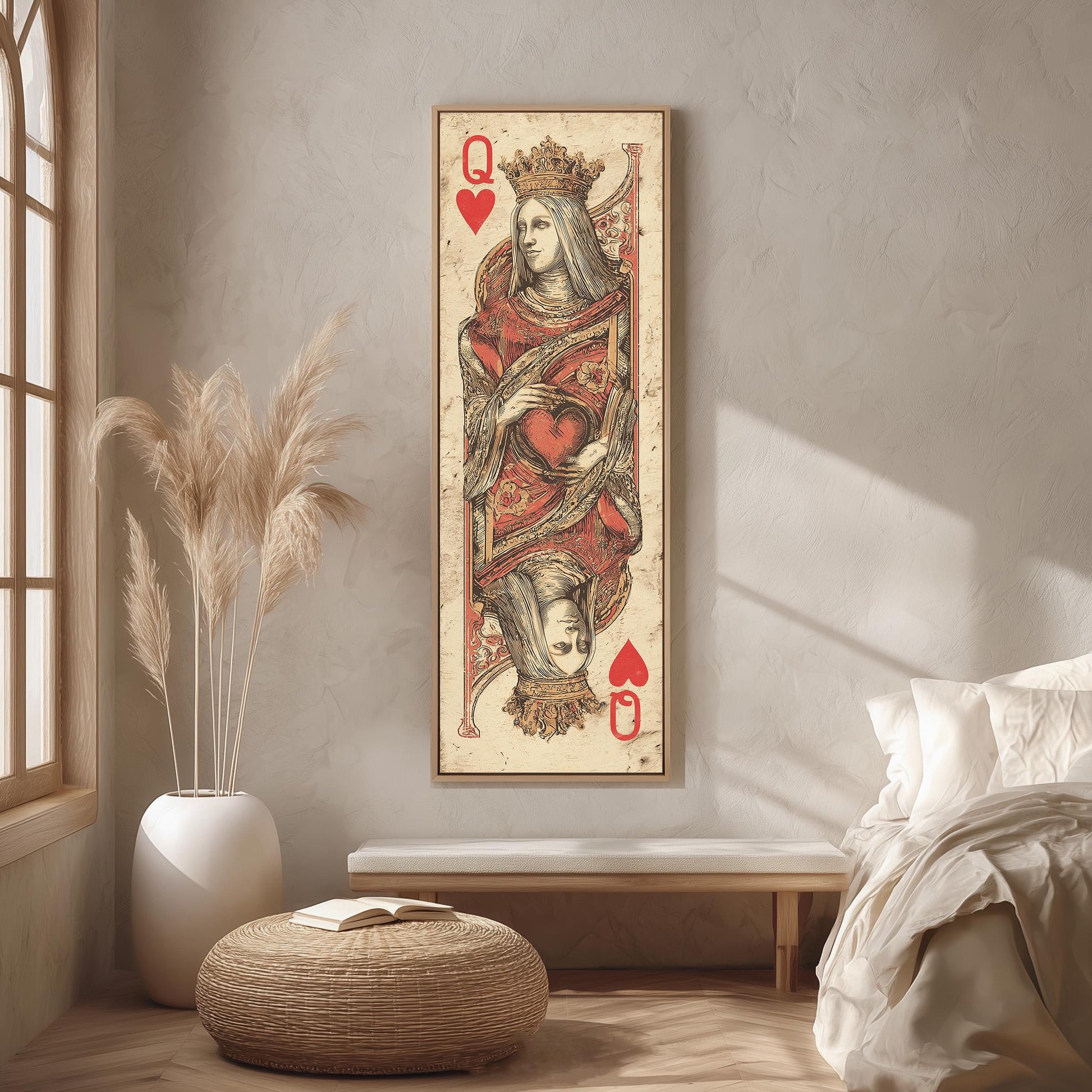 a large framed artwork depicting a queen of spades playing card, hanging on a wall in a room with a bed, a potted plant, and a woven ottoman.