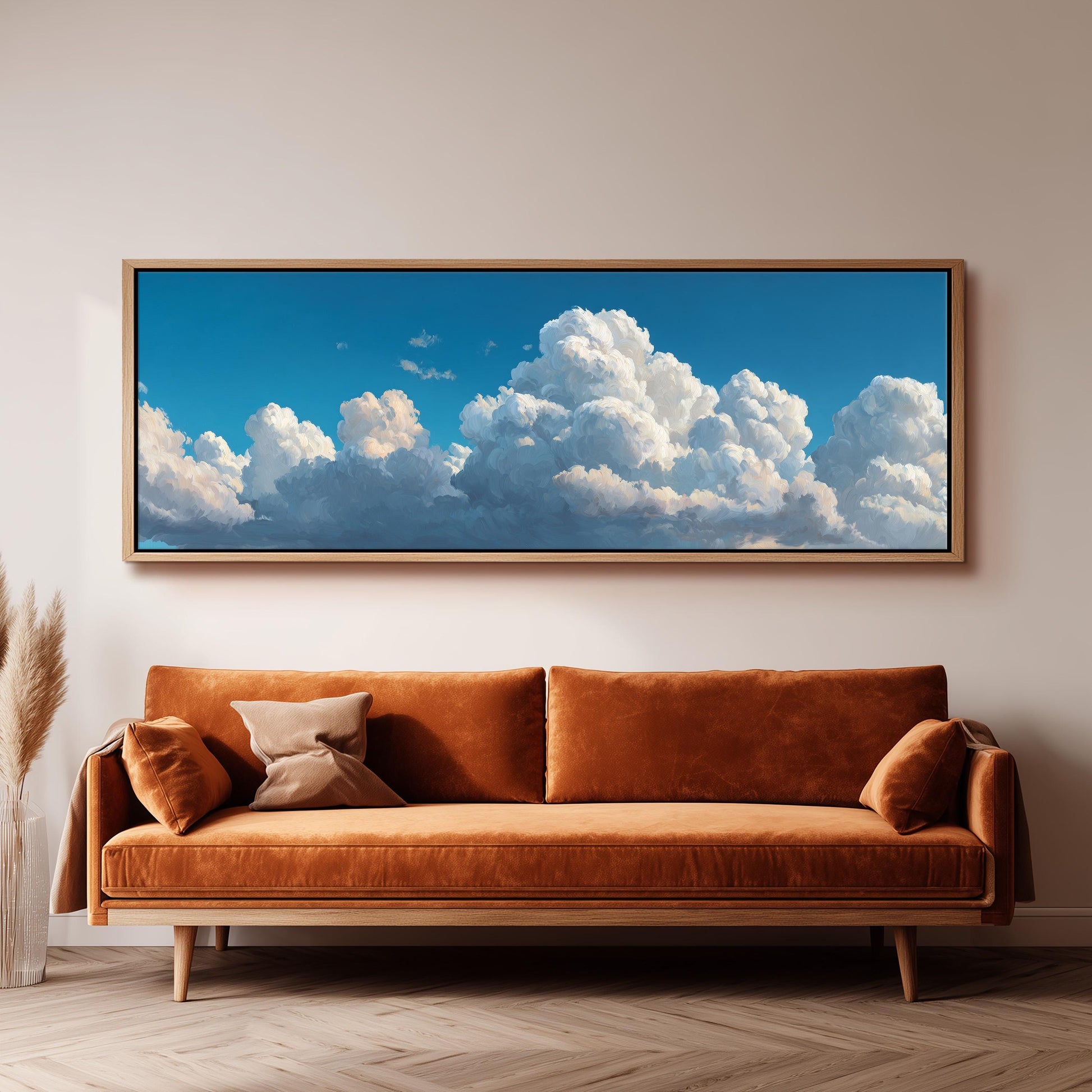 a large, framed painting of a blue sky with fluffy white clouds hanging on a wall above a brown sofa.