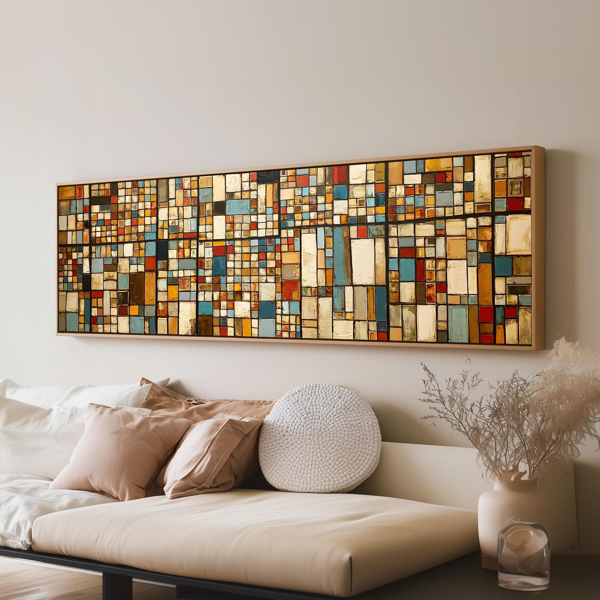 Earth tone mosaic grid in blue and ochre long horizontal canvas print above a sofa in a living room