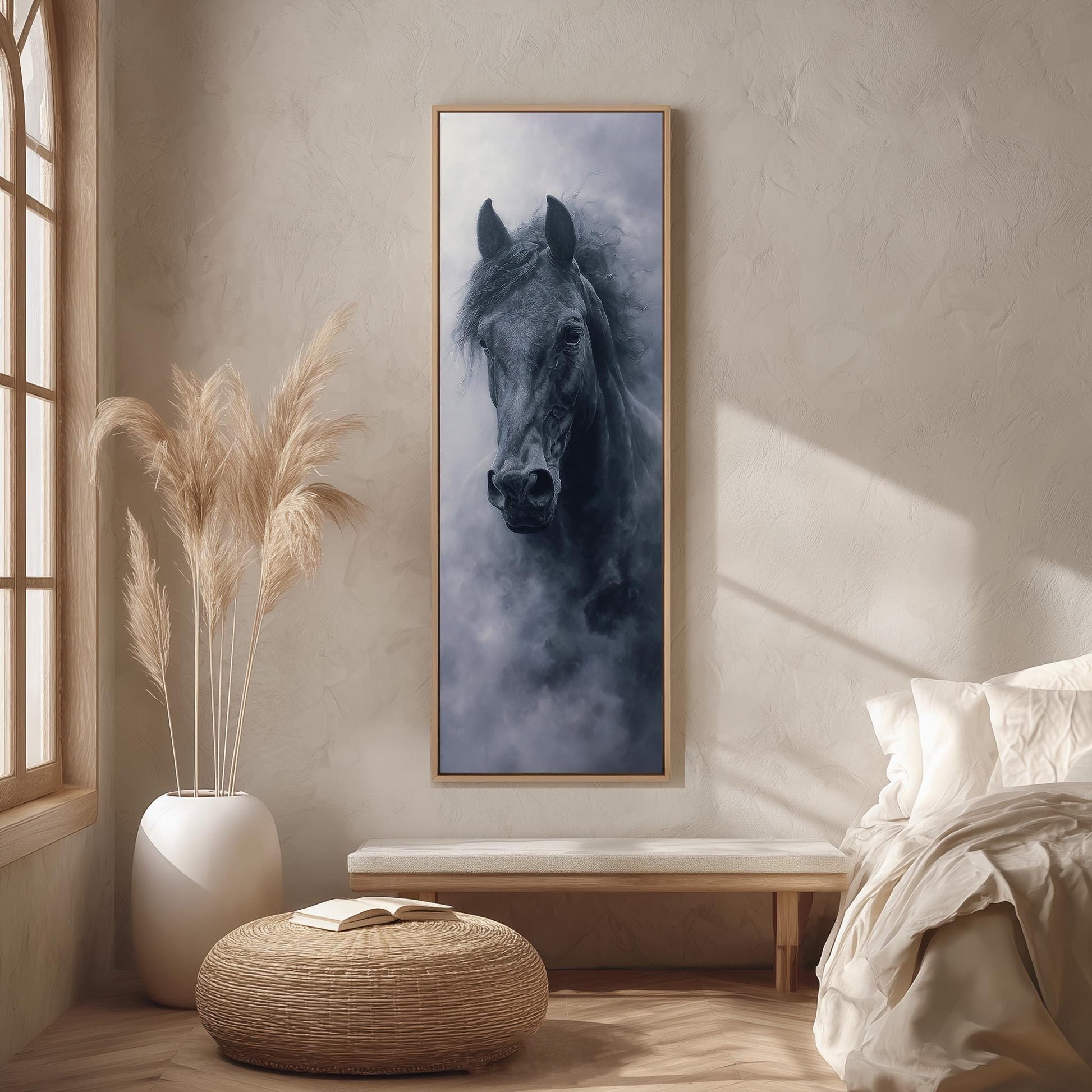 a large black horse in a dark frame, hanging on a wall in a room with a window, a white bed, and a woven ottoman.