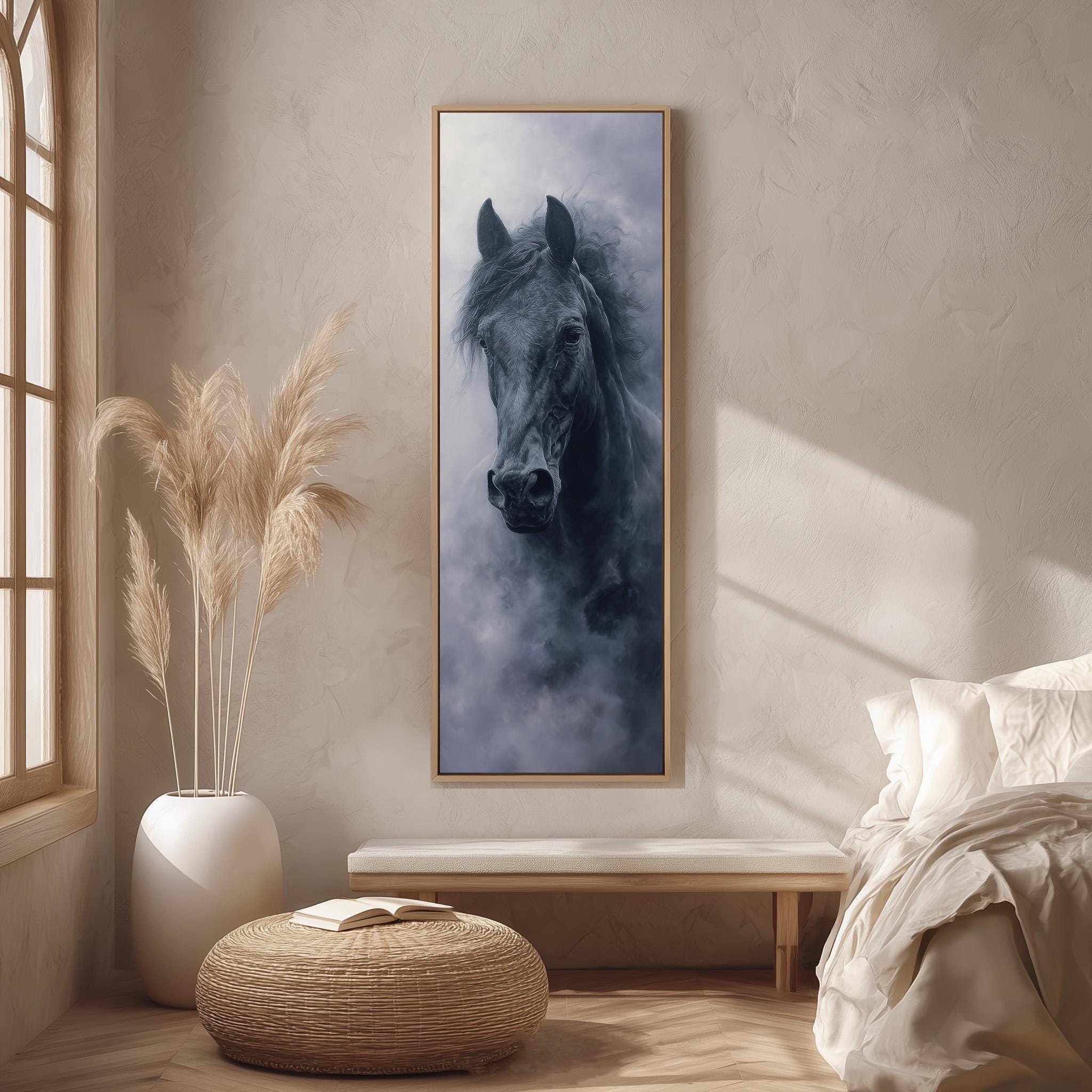 a large black horse in a dark frame, hanging on a wall in a room with a window, a white bed, and a woven ottoman.
