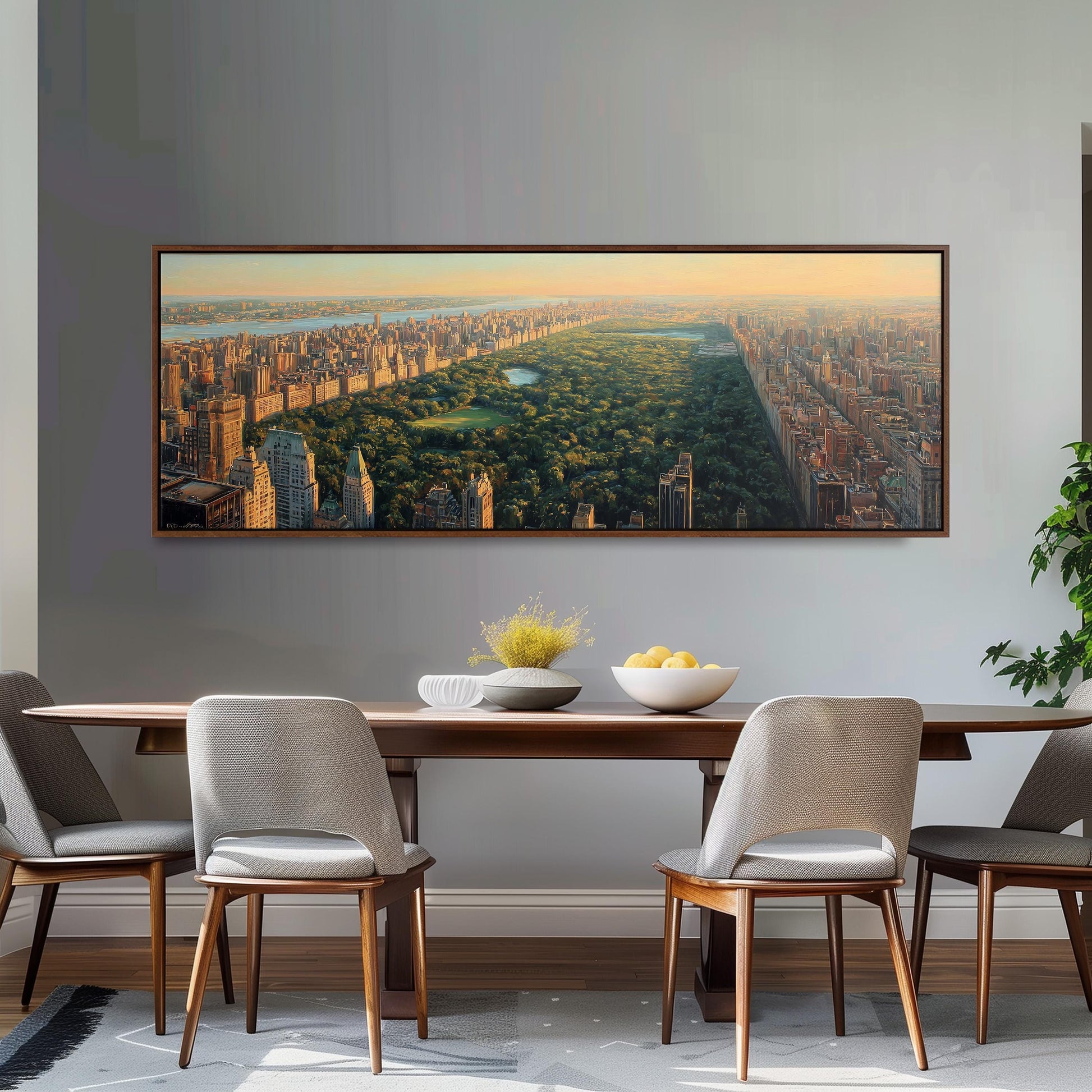 a large, framed painting of a cityscape with a park in the foreground, hanging on a wall above a wooden dining table with four chairs.