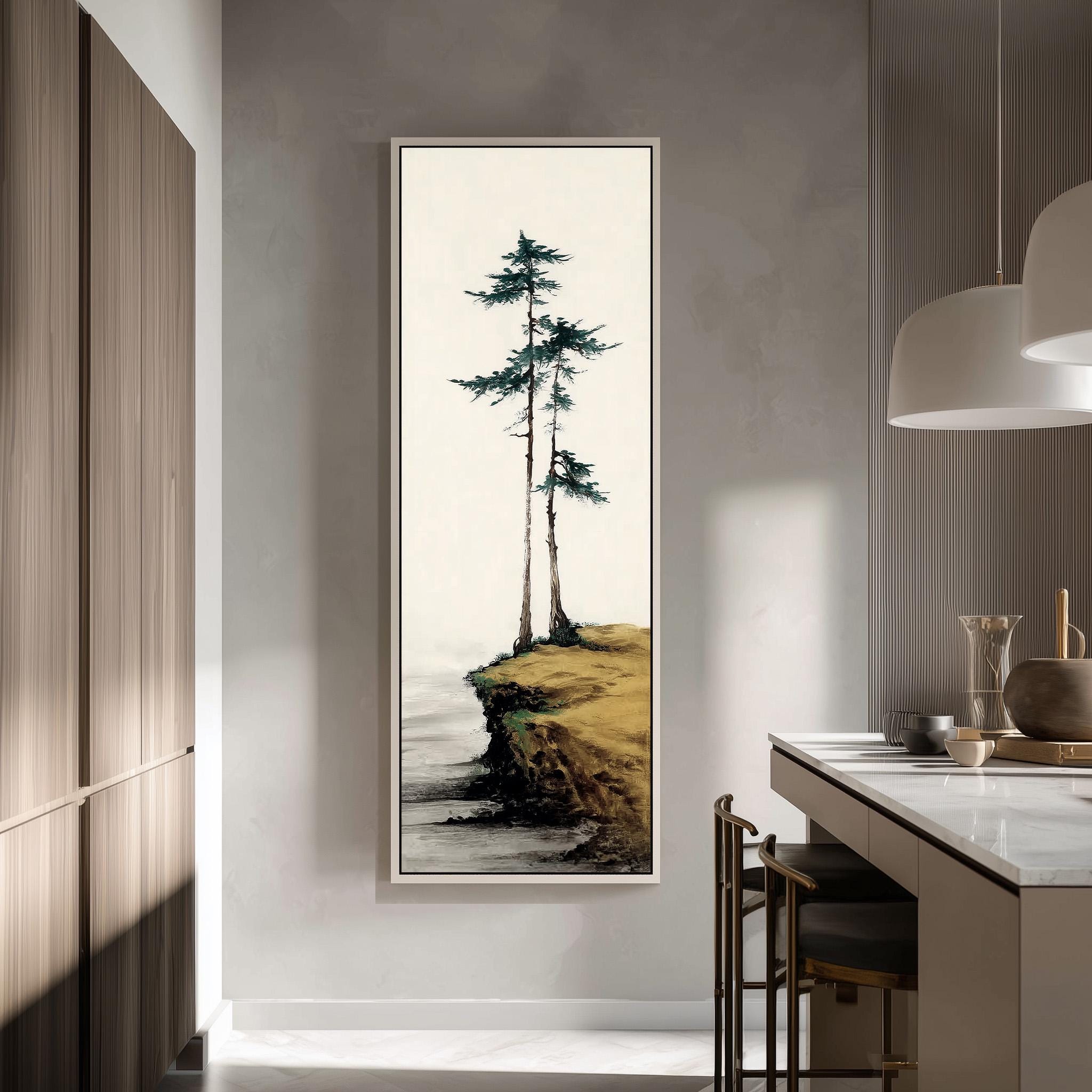 a large framed painting of a serene landscape with two tall trees on a cliff overlooking a body of water. The painting is hung on a wall in a modern kitchen with a minimalist design.
