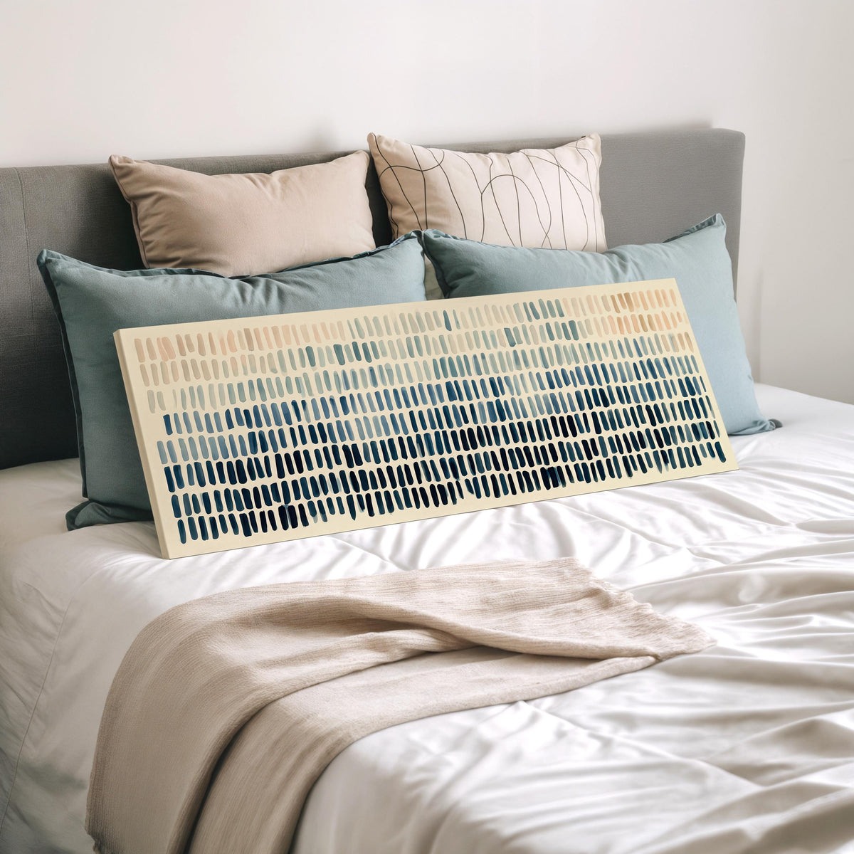 Brushmarks fading from peach to navy wide panoramic canvas print laid on a bed to show its size
