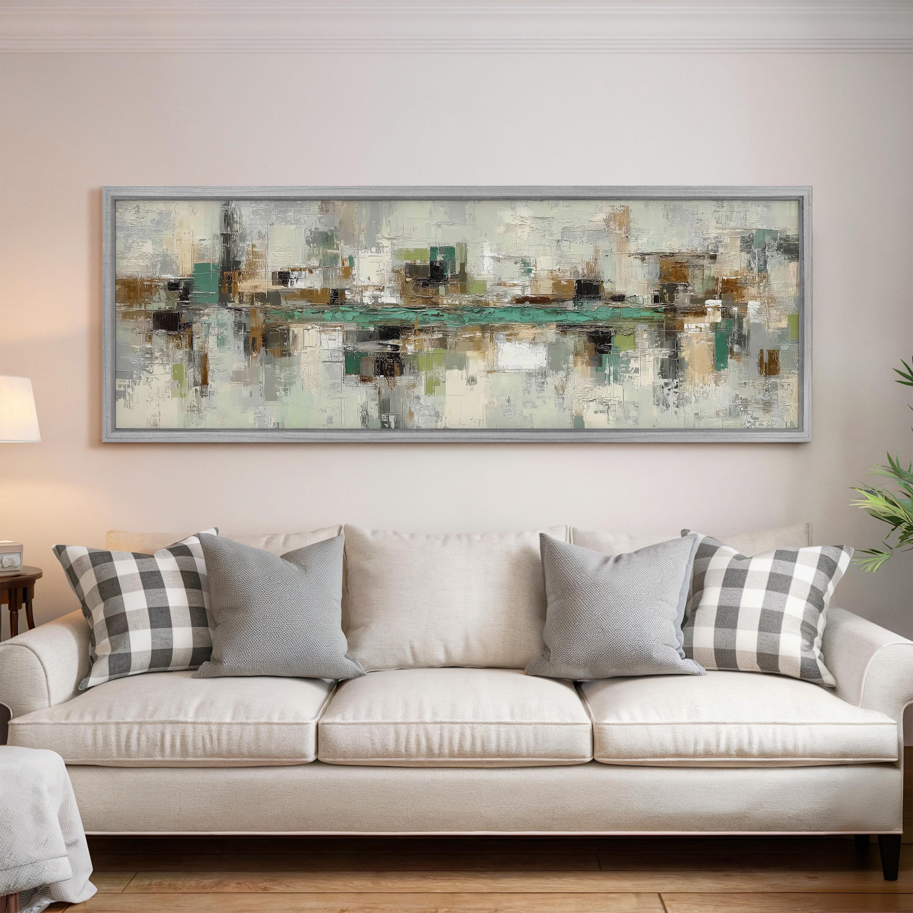a large abstract painting hanging on a wall above a white sofa with gray and white patterned pillows.