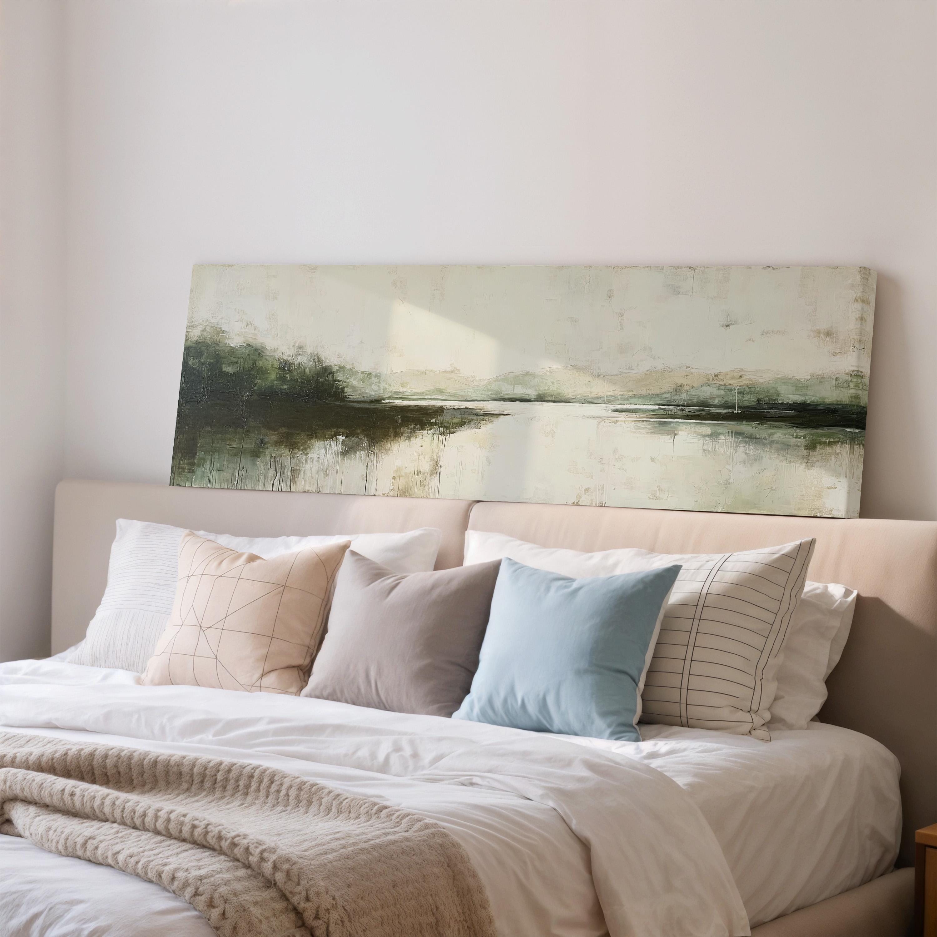 a cozy bedroom with a large bed adorned with white linens and a variety of colorful throw pillows. Above the bed, there is a painting of a landscape, adding an artistic touch to the room's decor.