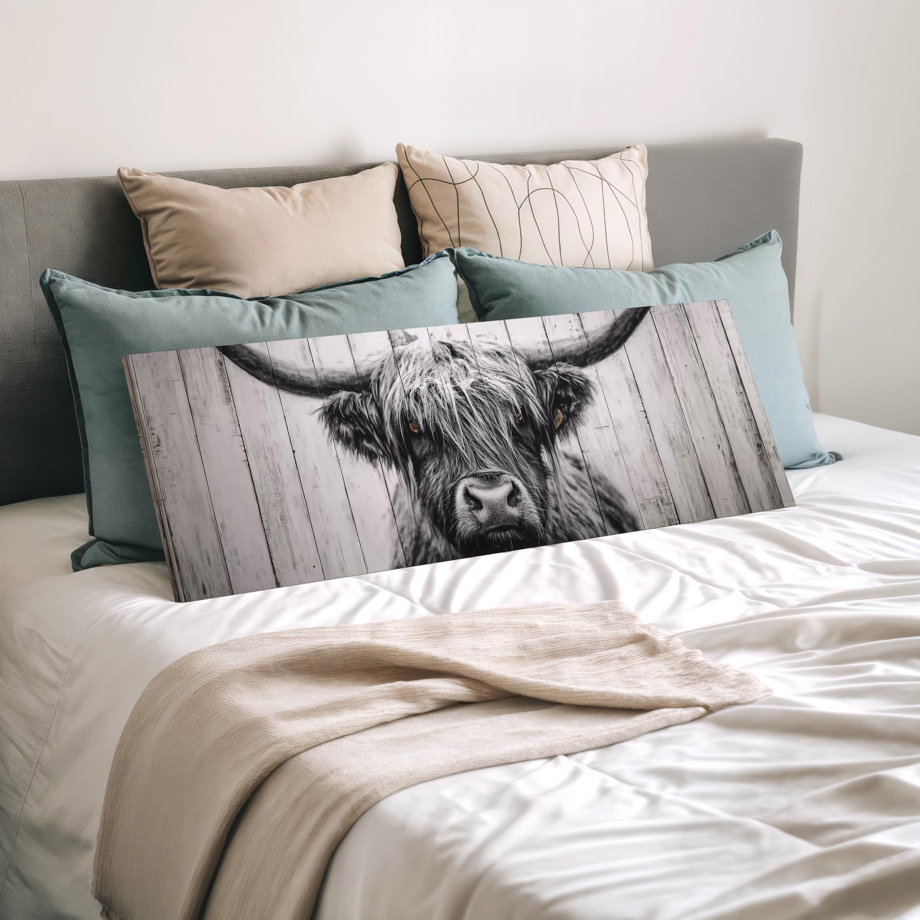 a bed with a large wooden fence with a cow's head on it, surrounded by pillows.