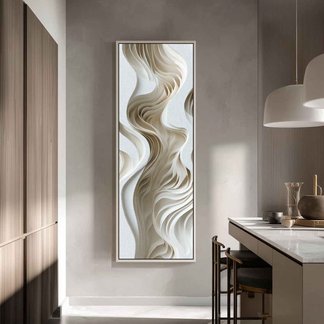 a modern kitchen with a large abstract artwork hanging on the wall. The artwork has a swirling, organic design in shades of white and beige, creating a sense of movement and fluidity. The kitchen is well-lit, with a pendant light hanging above the countertop and a wooden cabinet visible on the left side of the image.