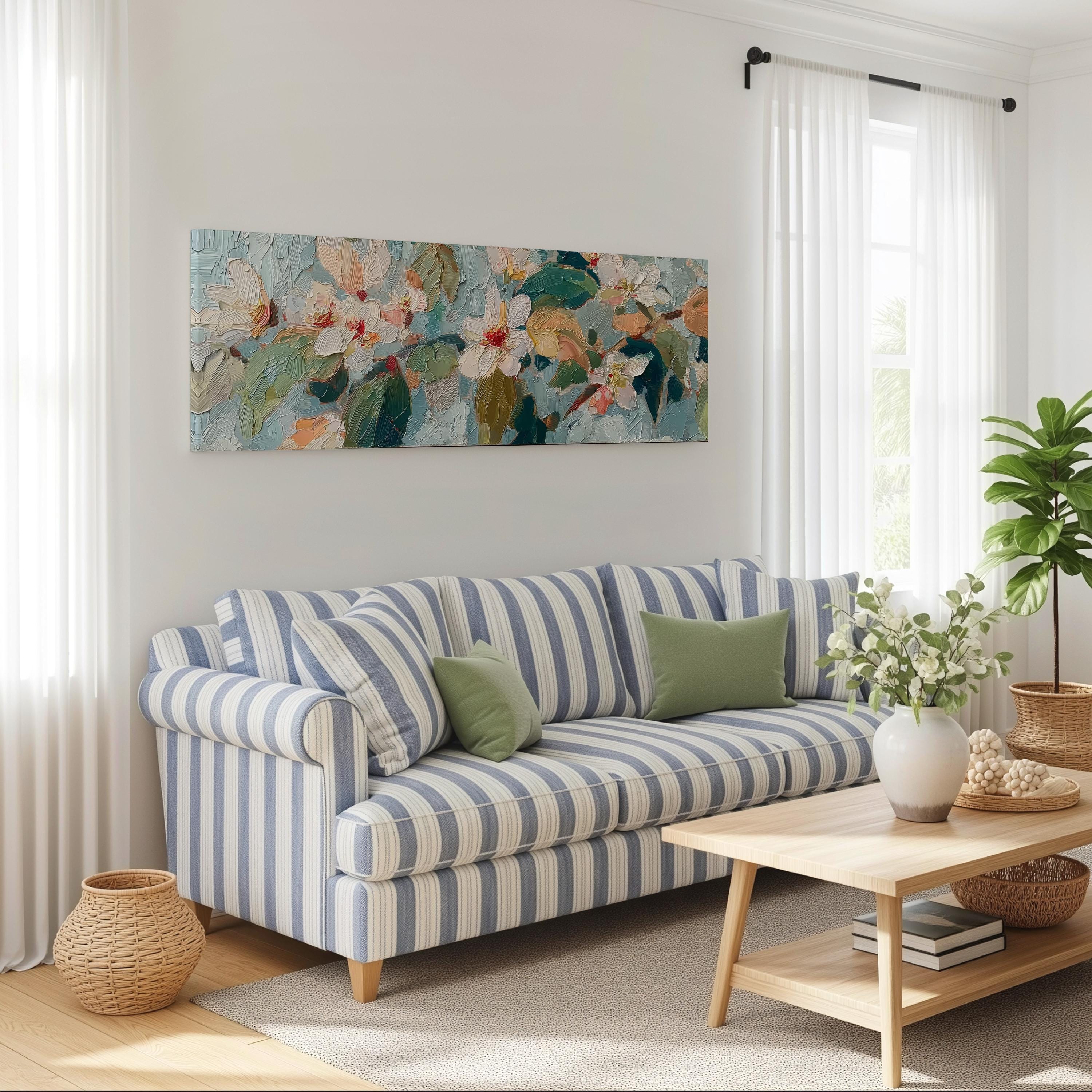 a cozy living room with a striped blue and white sofa, a wooden coffee table, and a large floral painting hanging on the wall above the sofa.