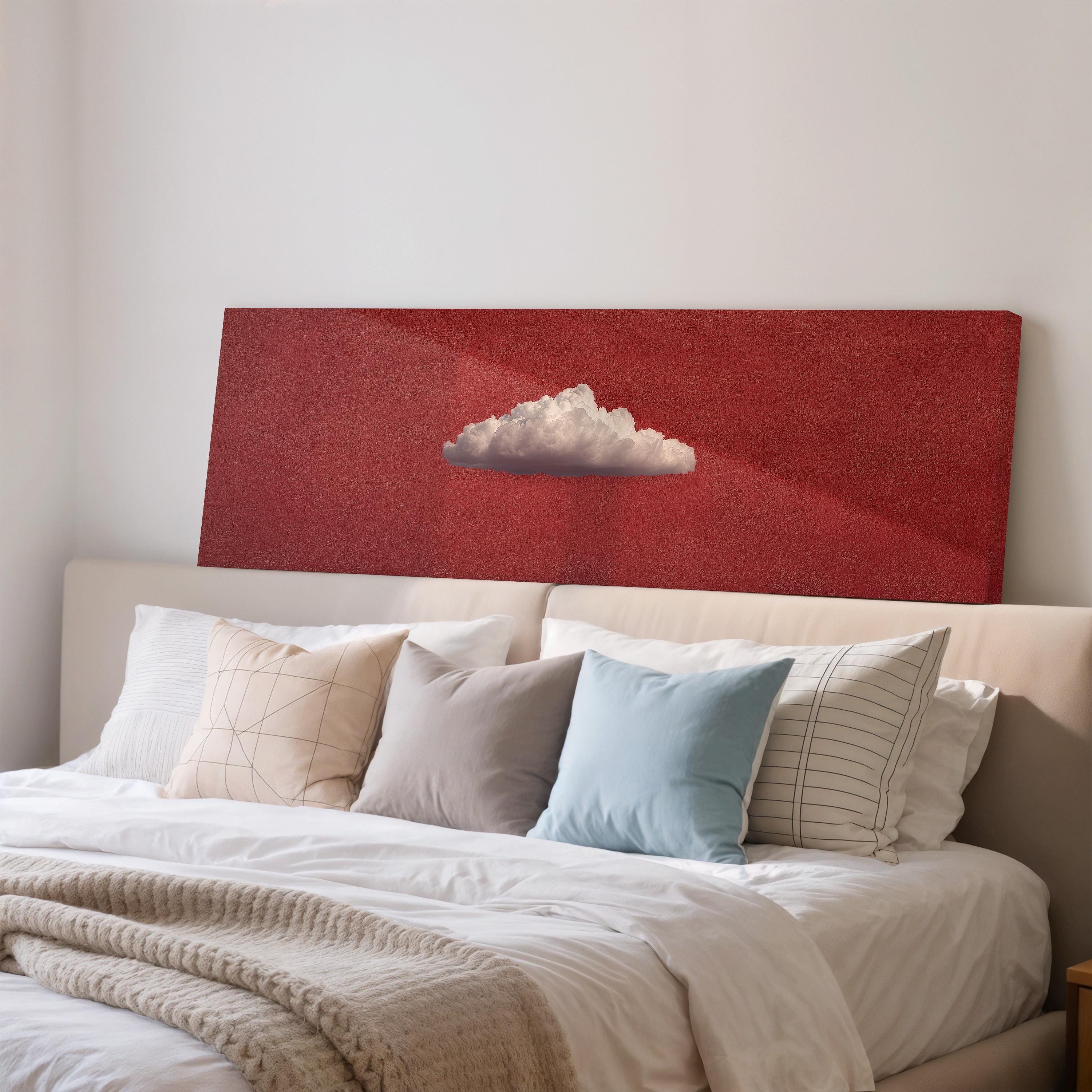 a cozy bedroom with a large bed adorned with white pillows and a blue throw blanket. Above the bed, there is a red canvas with a white cloud design on it.