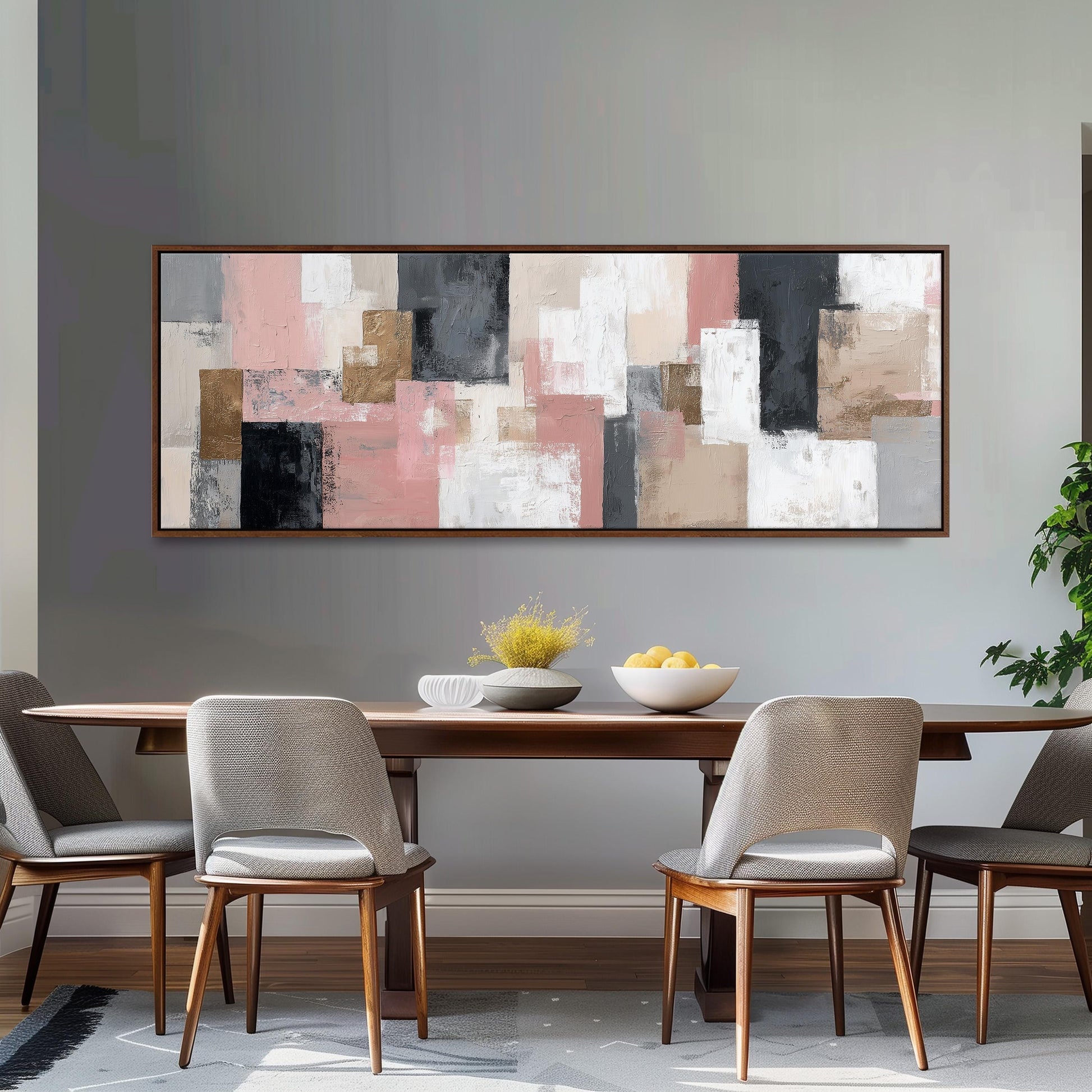 a dining room with a large abstract painting hanging on the wall above a wooden table with four chairs. The table is set with a bowl of fruit and a vase of flowers, creating a cozy and inviting atmosphere.