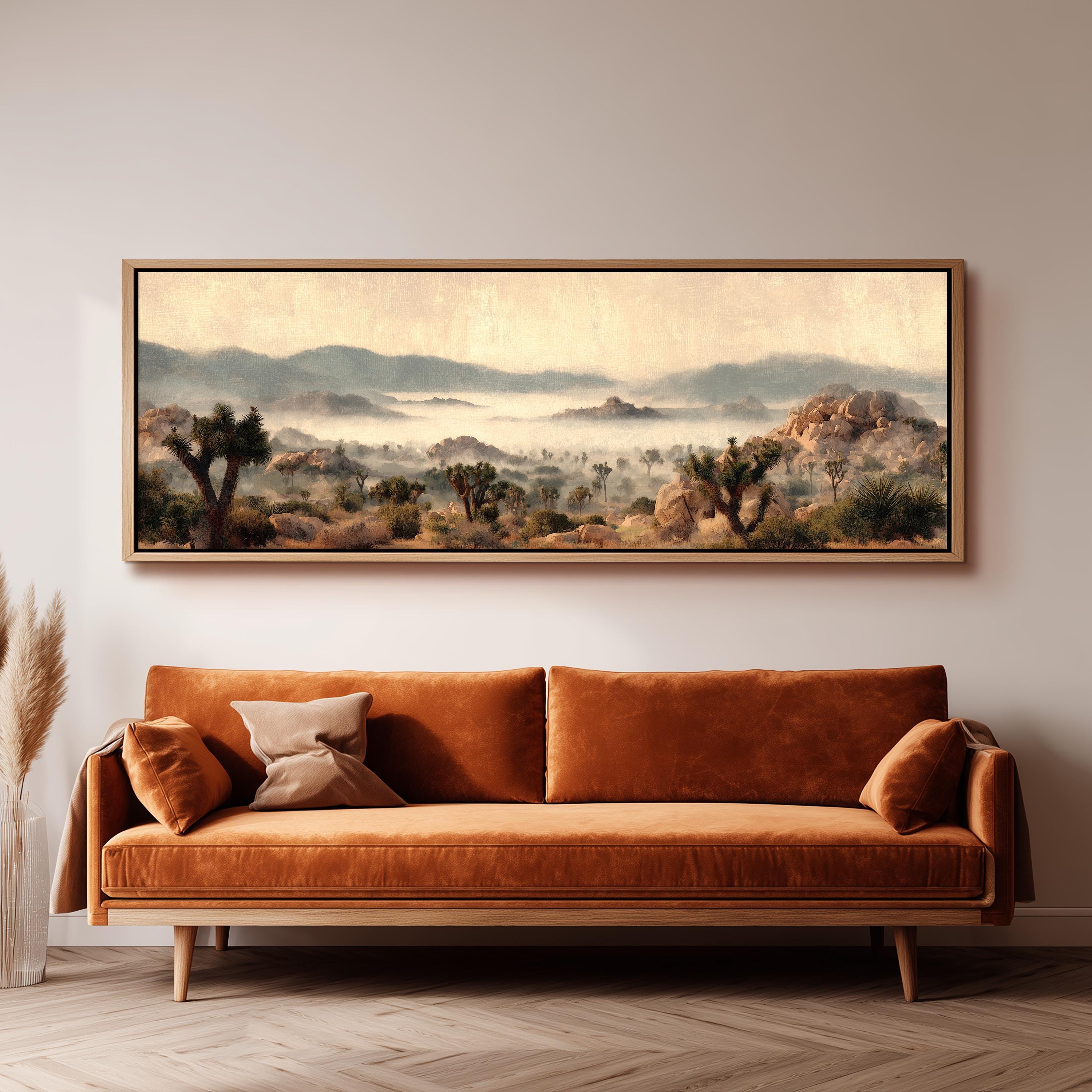 a large landscape painting hanging on a wall above a brown sofa with two pillows.