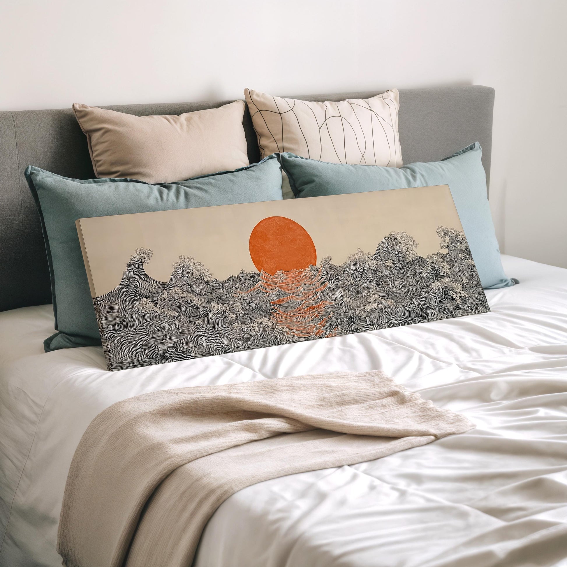 a large canvas print of a wave with an orange sun in the center, displayed on a bed with a white comforter and pillows.