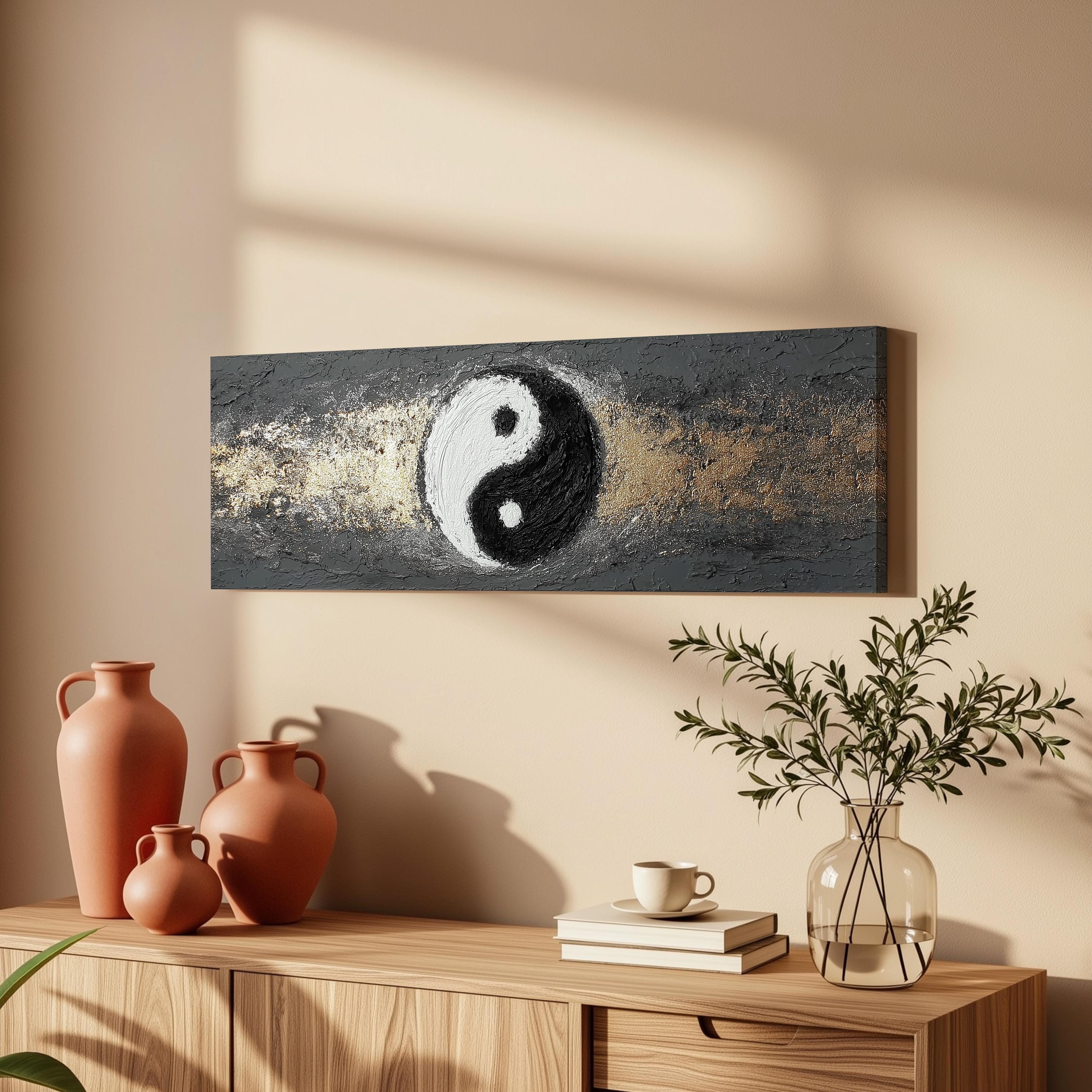 a wooden cabinet with a vase of greenery, a coffee cup, and a stack of books on top. Above the cabinet, there is a painting of a yin and yang symbol.