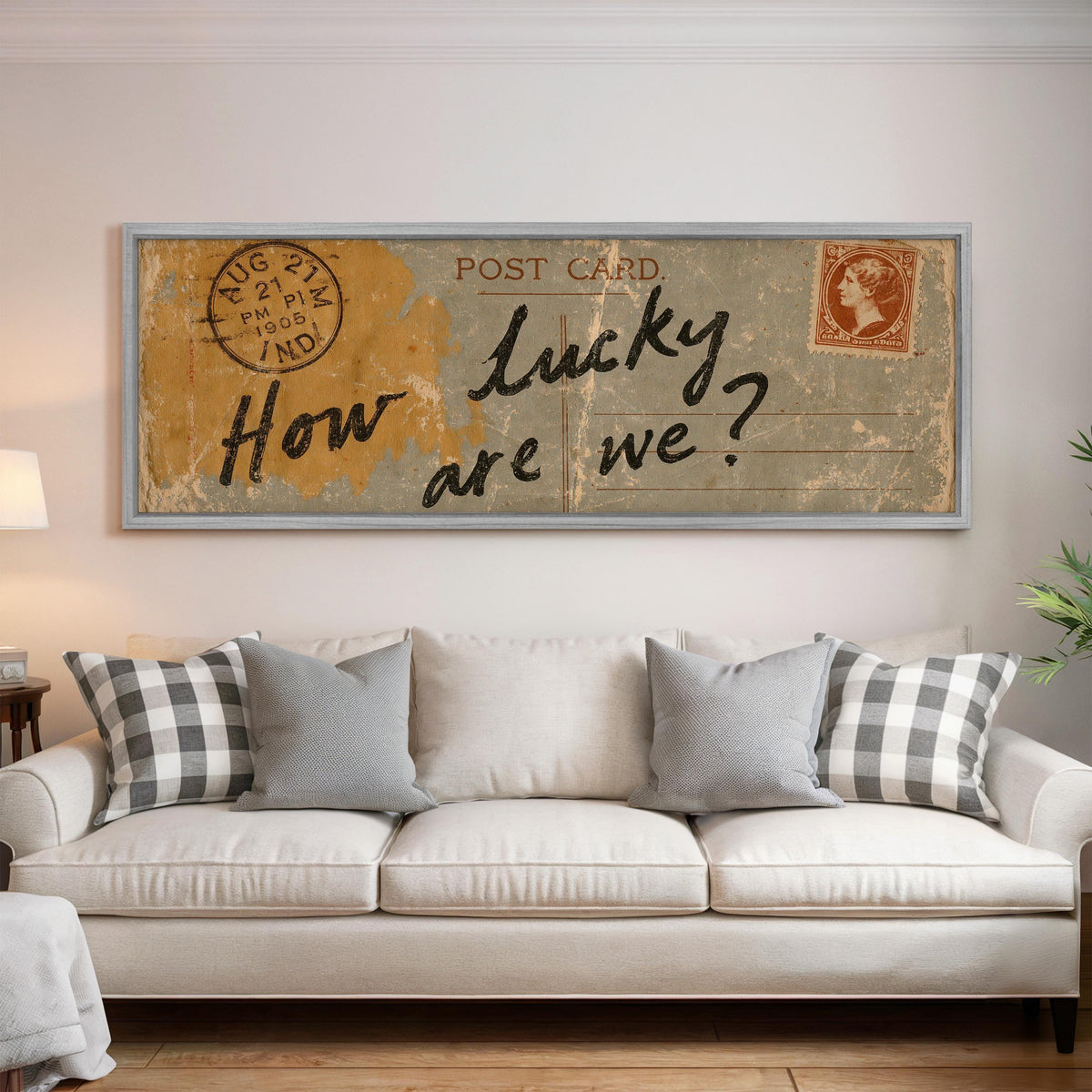 Vintage postcard saying how lucky are we panoramic canvas print above a white sofa in a bright living room